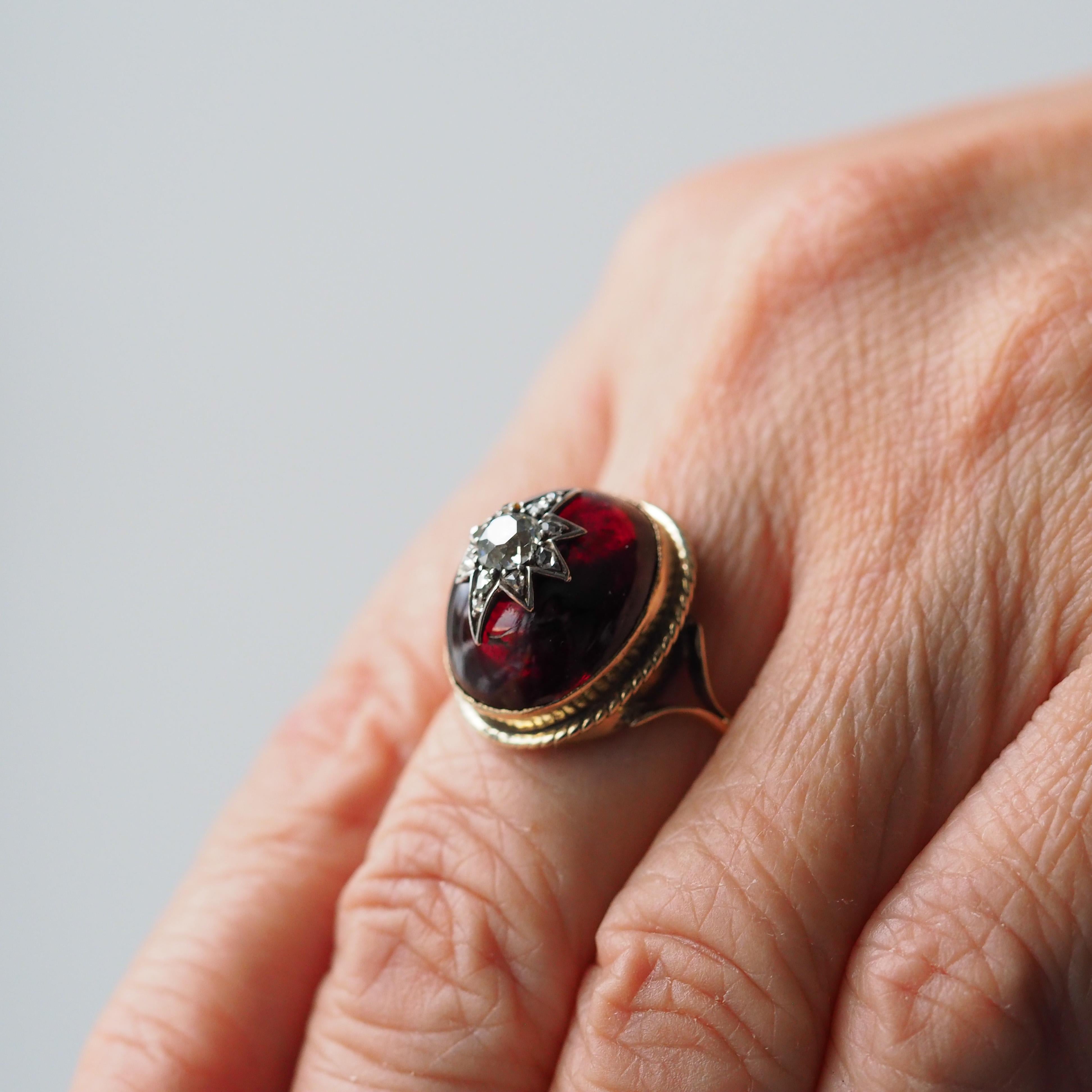 We are delighted to offer this gorgeous antique Victorian garnet cabochon and diamond star ring made c.1880.

This ring features a substantial garnet cabochon that has a wonderful curvature that not only has an impressive presence upon wearing but