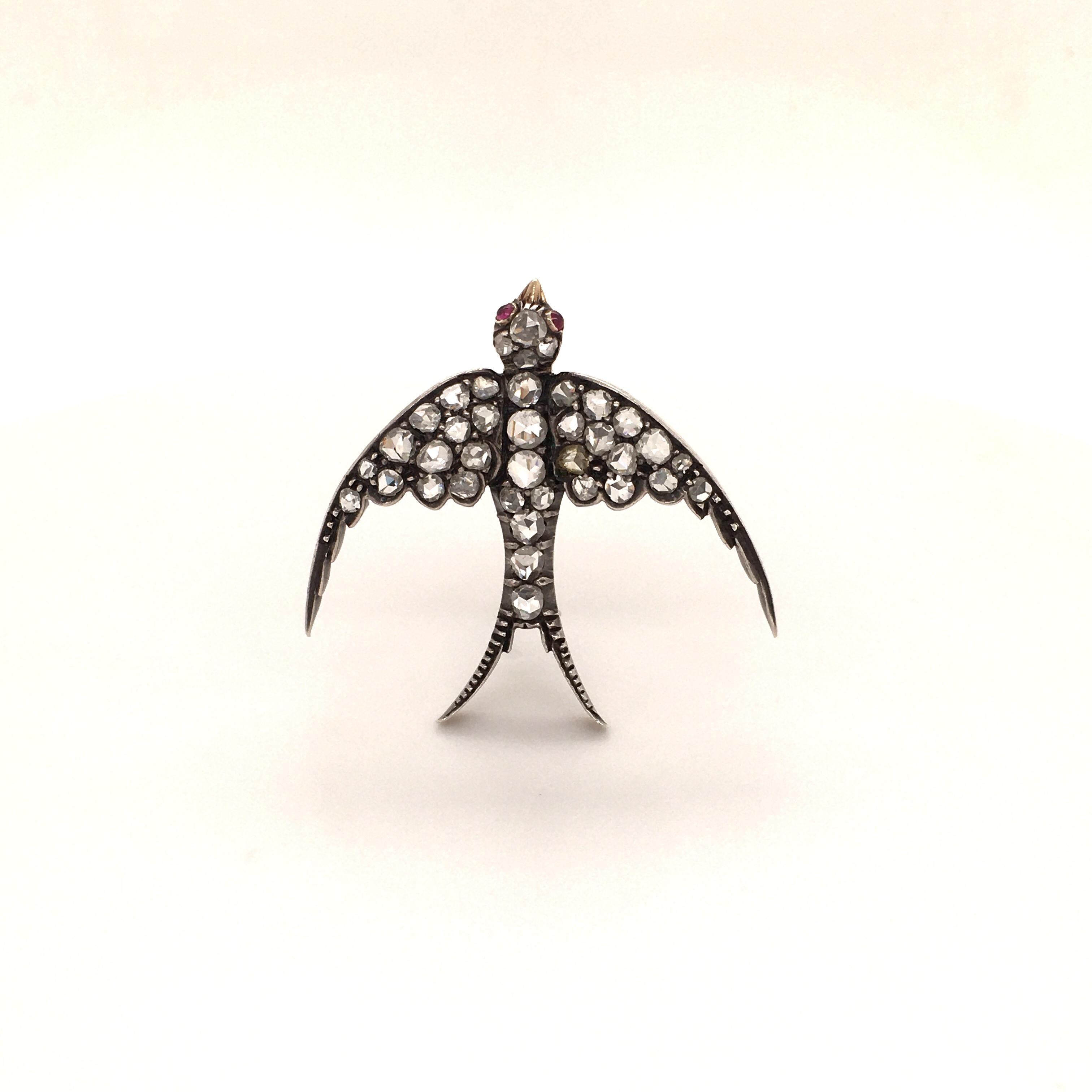 This marvelous Victorian swallow bird brooch is set with 38 rose cut diamonds, total weight approximately 0.76 carats. Two small ruby cabochons mark the eyes.
Superbly handcrafted in silver over 14 karat rose gold. Very fine condition.