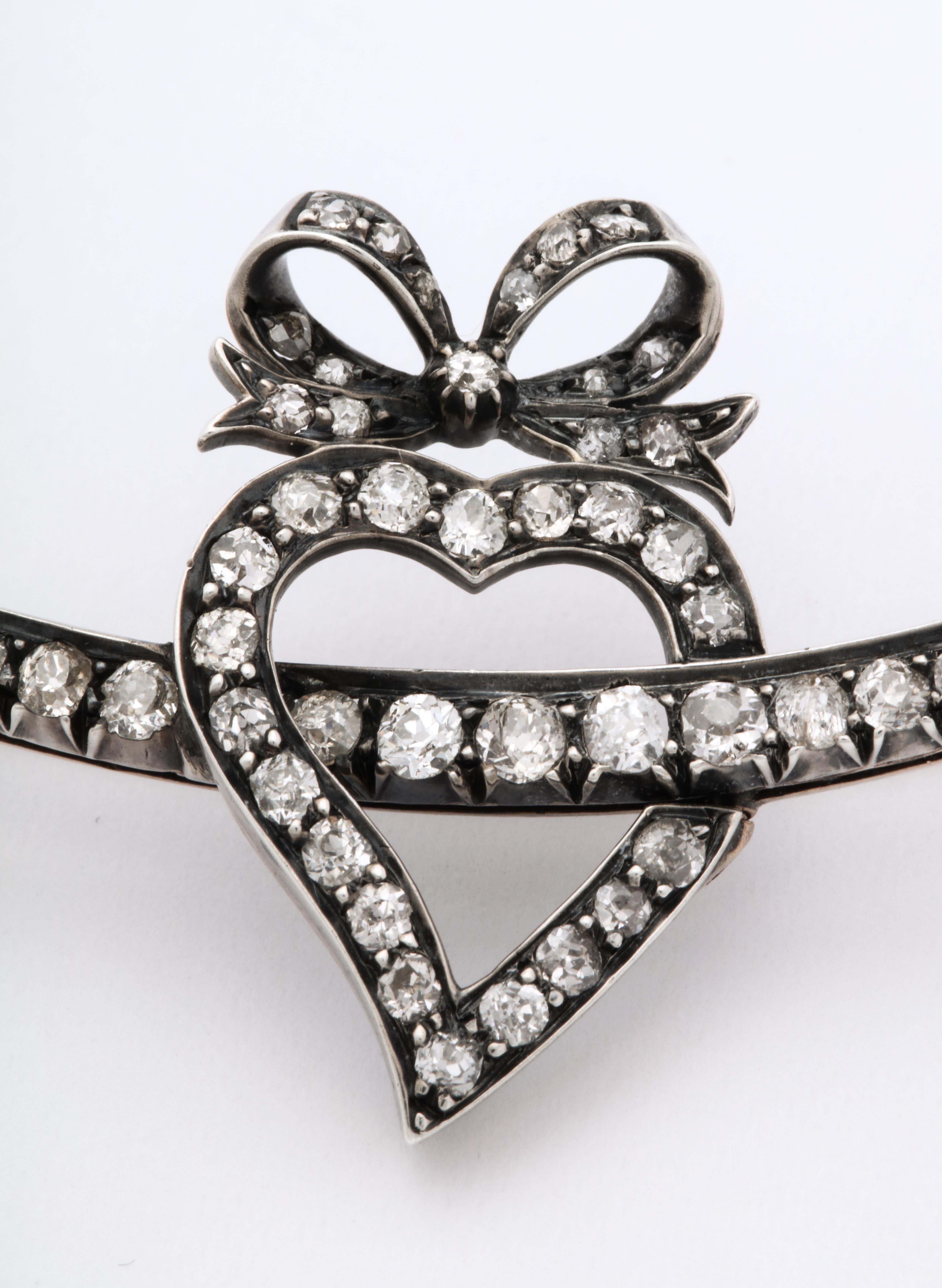 Seventy two sparkling old mine and european cut diamonds, set in 18kt gold and silver pronged settings, cover a witch's heart, crescent moon and bow in this Victorian brooch made in Great Britain c. 1860. The brooch was filled with symbolism for the