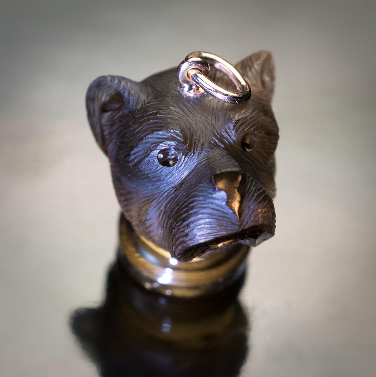Circa 1880

A Victorian era antique pendant – seal is designed as a dog’s head placed on a round pedestal. The pendant is carved from a single piece of smoky topaz and mounted with a 14K gold suspension ring. The base of the pendant was intended to