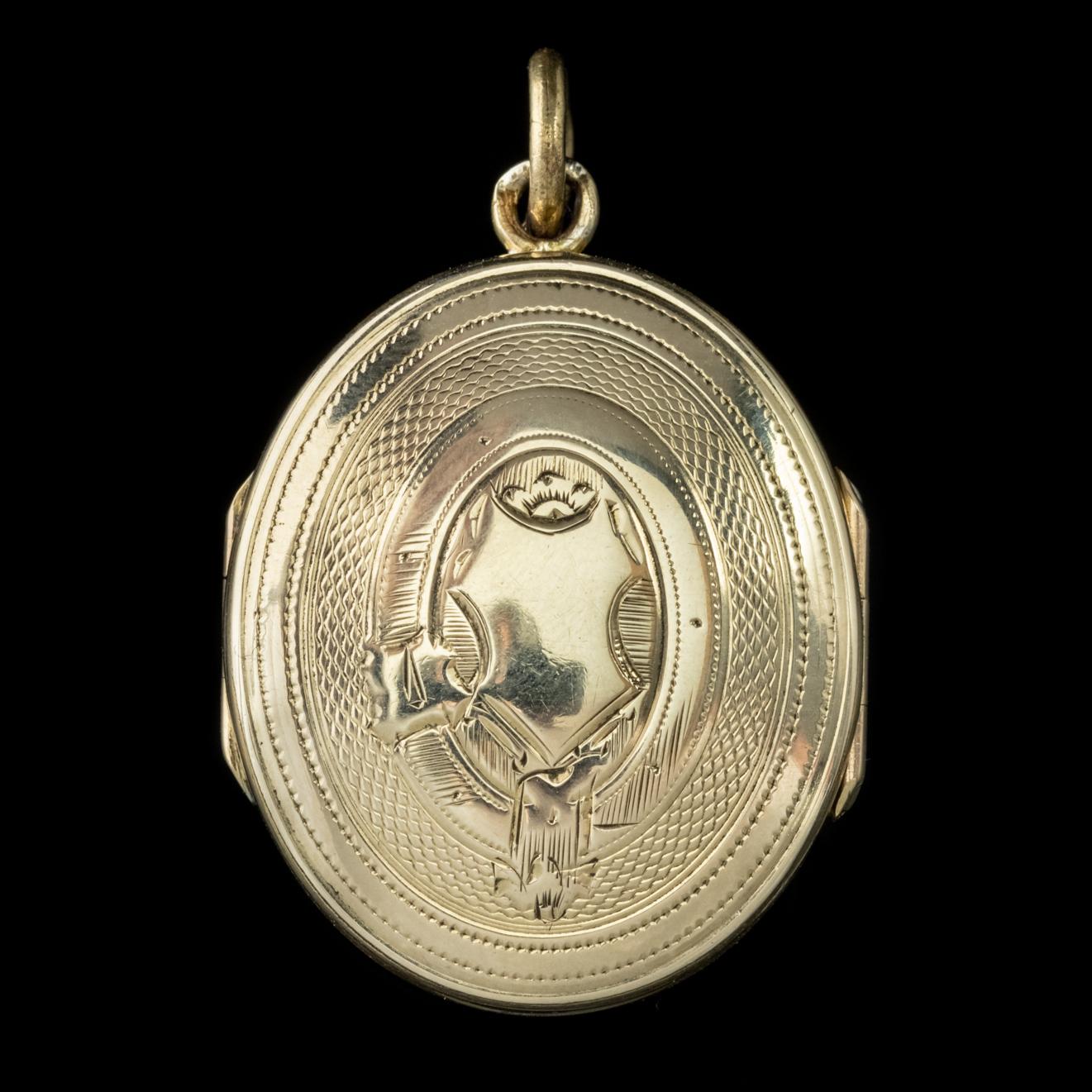 An exquisite Antique Victorian family locket modelled in 9ct Yellow Gold featuring detailed engraved patterning on the front and back with two central shields in which initials can be added. 

A belt and buckle can be seen encircling the central
