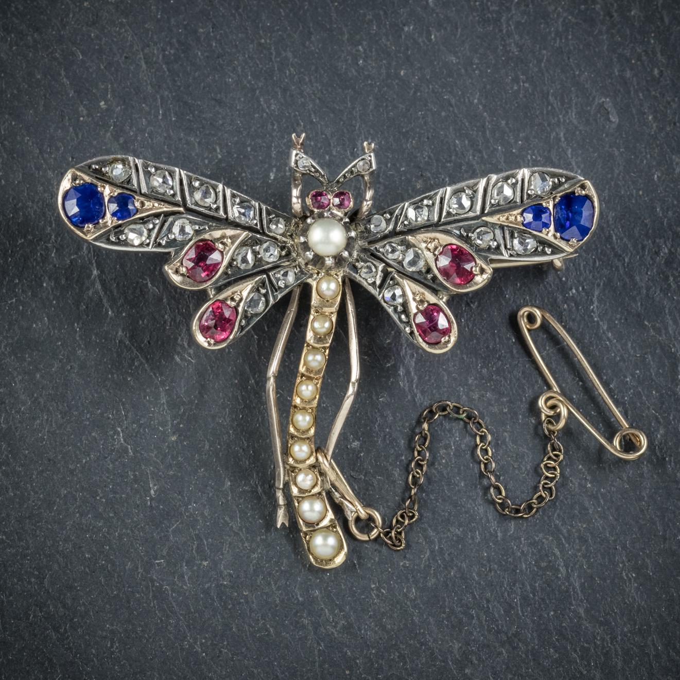This delightful antique gemstone Dragonfly brooch was beautifully made during the Victorian era, Circa 1900. 

The lovely Insects wings are decorated in approx. 0.30ct of Sapphire, 0.40ct of Ruby and 0.80ct of rose cut Diamond with a line of Pearls