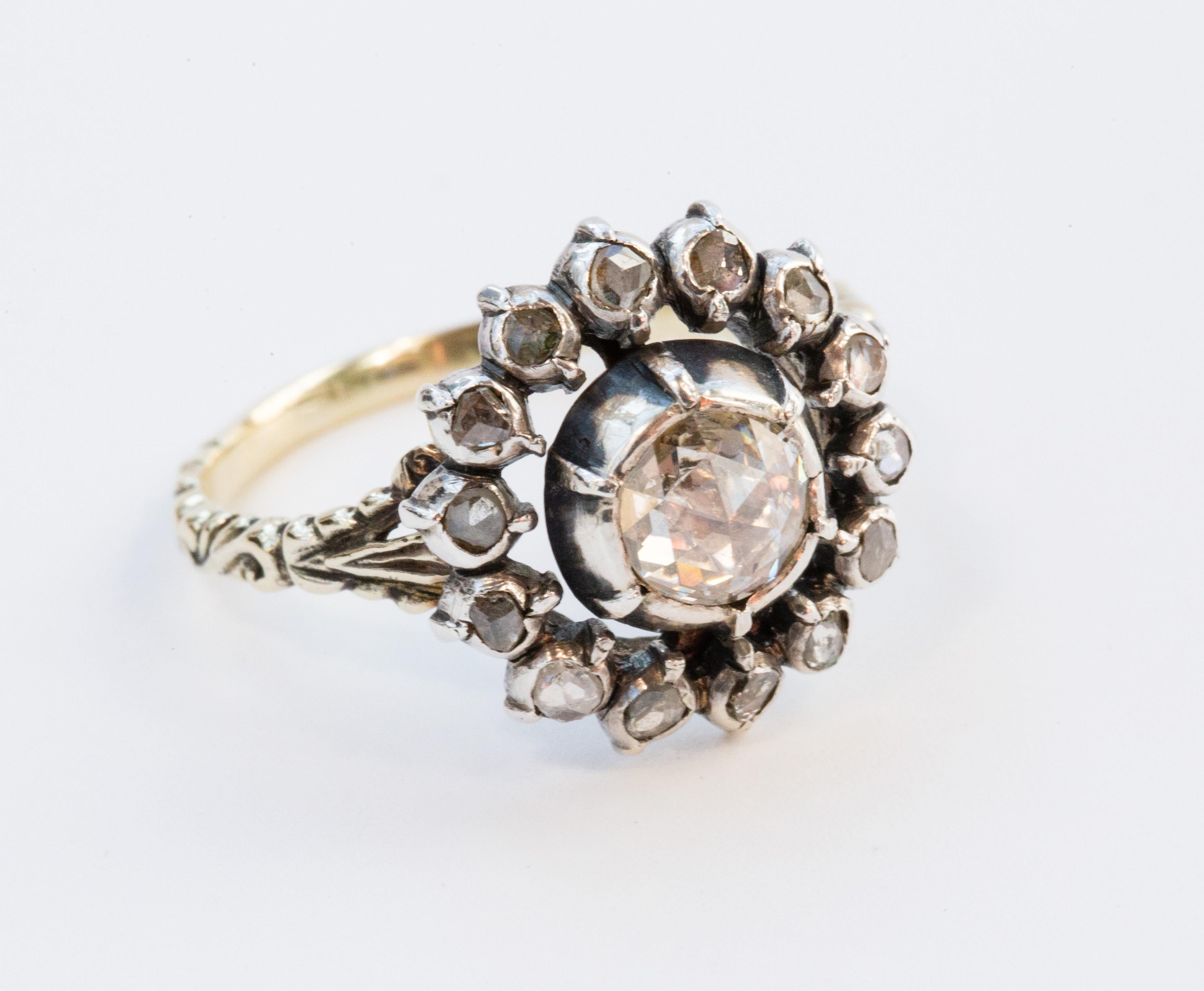 Un antico anello vittoriano (ca. 1900) con diamanti a grappolo. L'anello è realizzato in oro giallo 14 carati e un diamante centrale taglio rosa circondato da piccoli diamanti taglio rosa (14 diamanti). I diamanti sono incastonati in una lamina