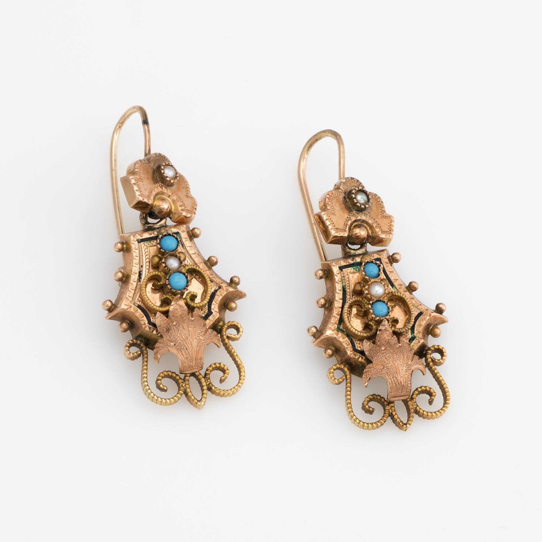 Elegant pair of antique Victorian earrings (circa 1880s to 1900s), crafted in 10k rose gold. 

Four cabochon cut pieces of turquoise measure 1.5mm, accented with four 1.5mm seed pearls.  

The striking earrings feature foliate detail to the scrolled