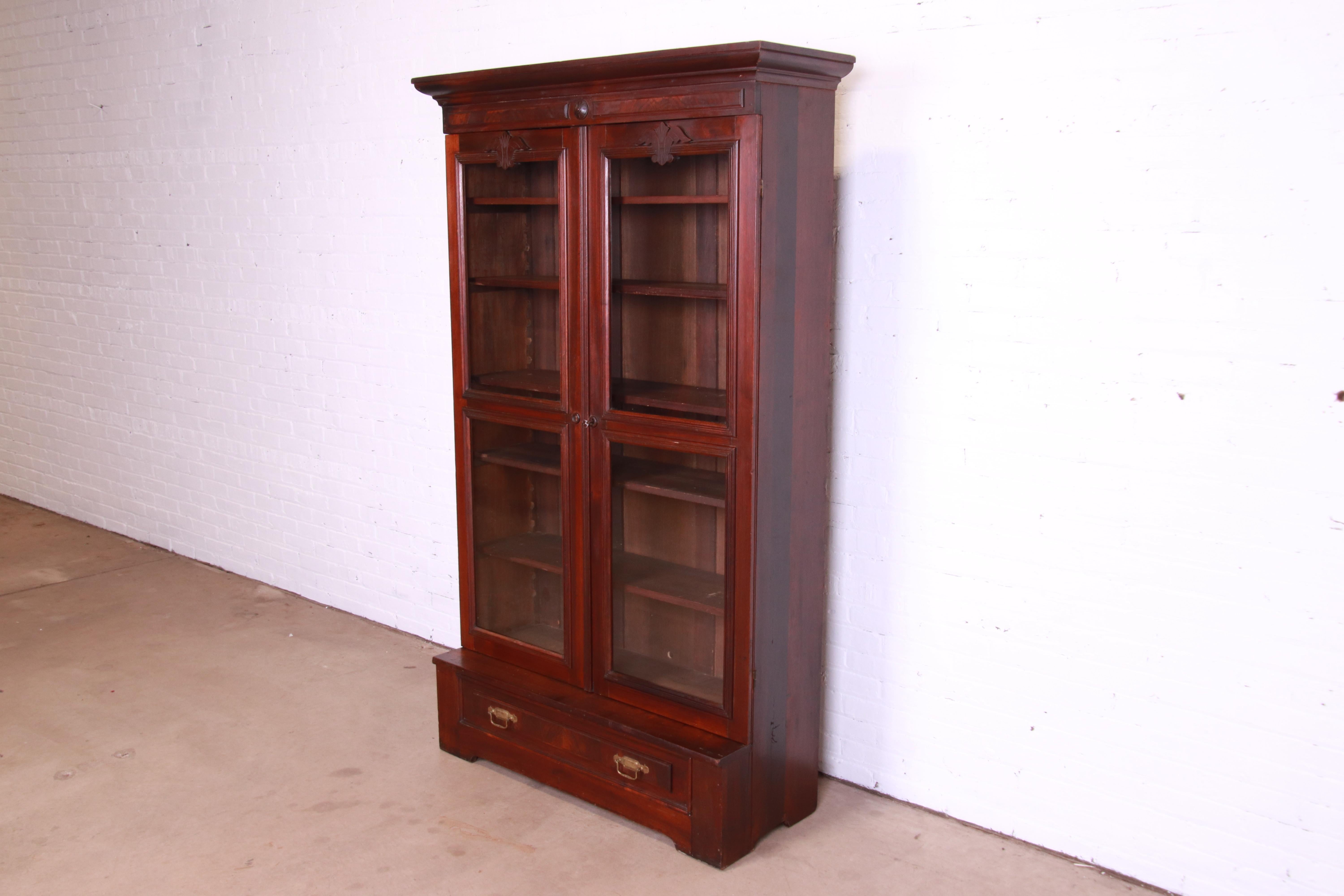 A beautiful antique Victorian Eastlake bookcase

USA, Circa 1880s

Carved walnut, with burled walnut accents, glass front doors, and original brass hardware.

Measures: 47.75