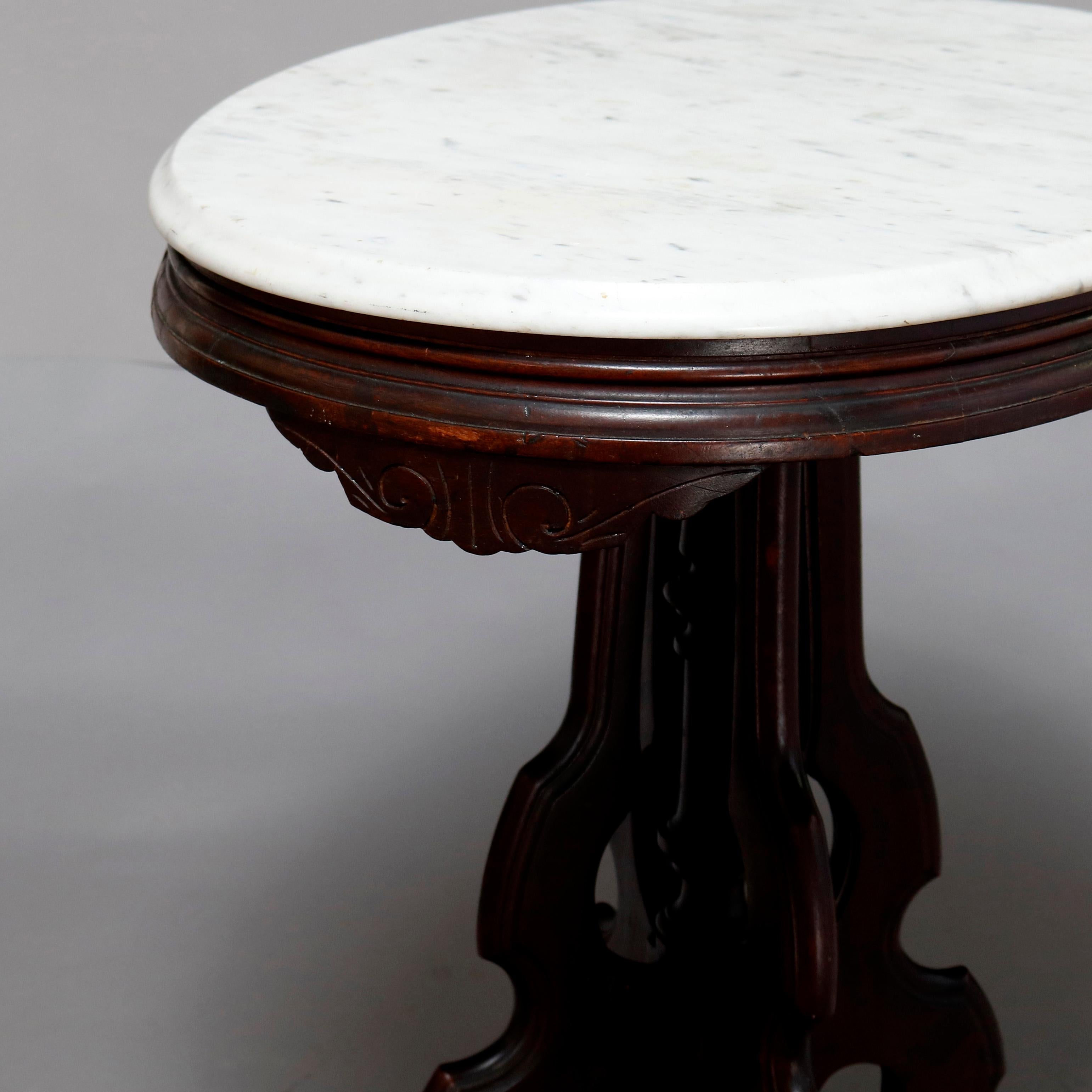 An antique Victorian Eastlake side table offers a beveled oval marble top surmounting carved walnut frame having shaped skirt, raised on shaped legs with central turned column and drop finial, circa 1880

***DELIVERY NOTICE – Due to COVID-19 we have