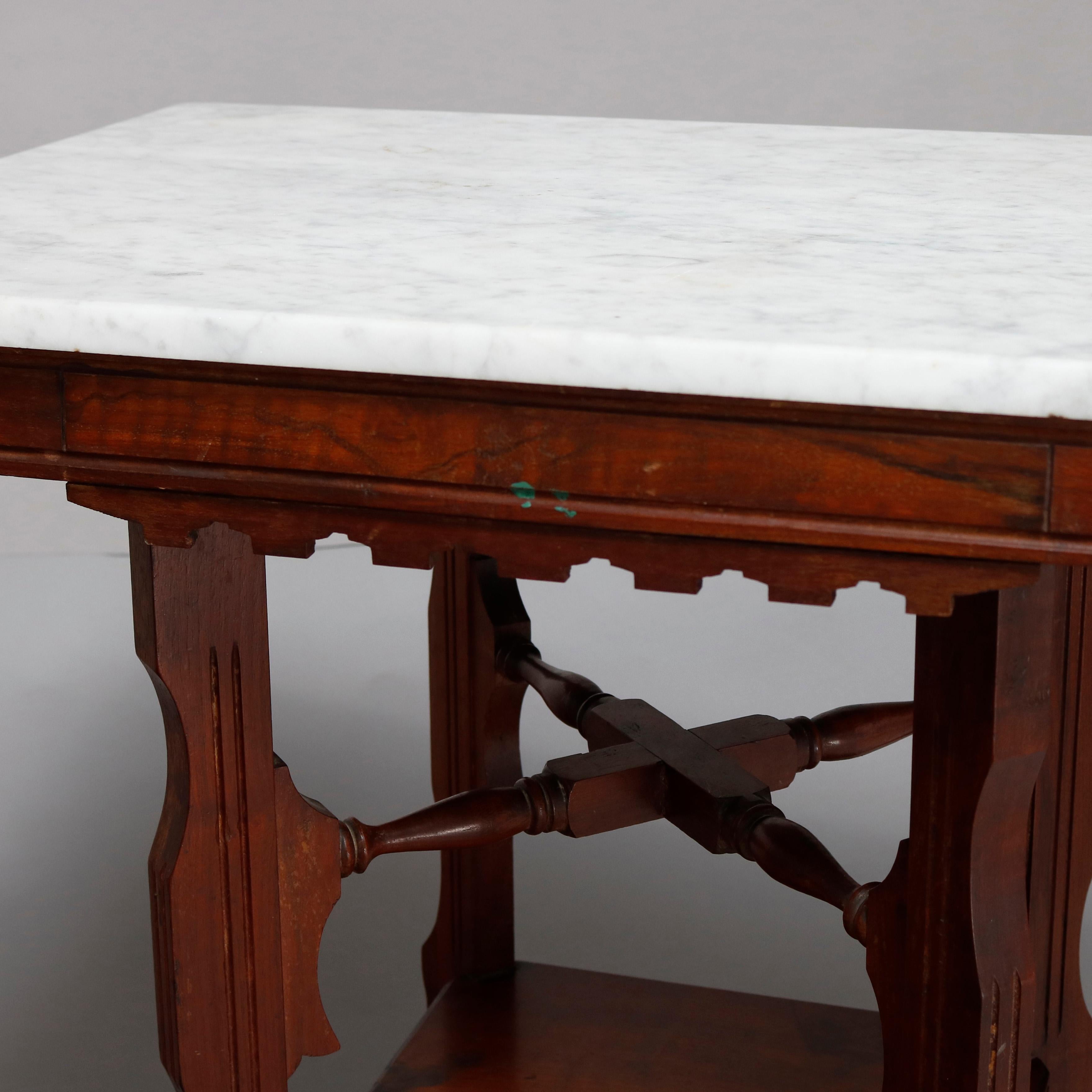 An antique Victorian Eastlake side table offers a rectangular marble top surmounting carved walnut frame having shaped skirt, raised on shaped legs with x-stretcher and lower display shelf, circa 1880

***DELIVERY NOTICE – Due to COVID-19 we are