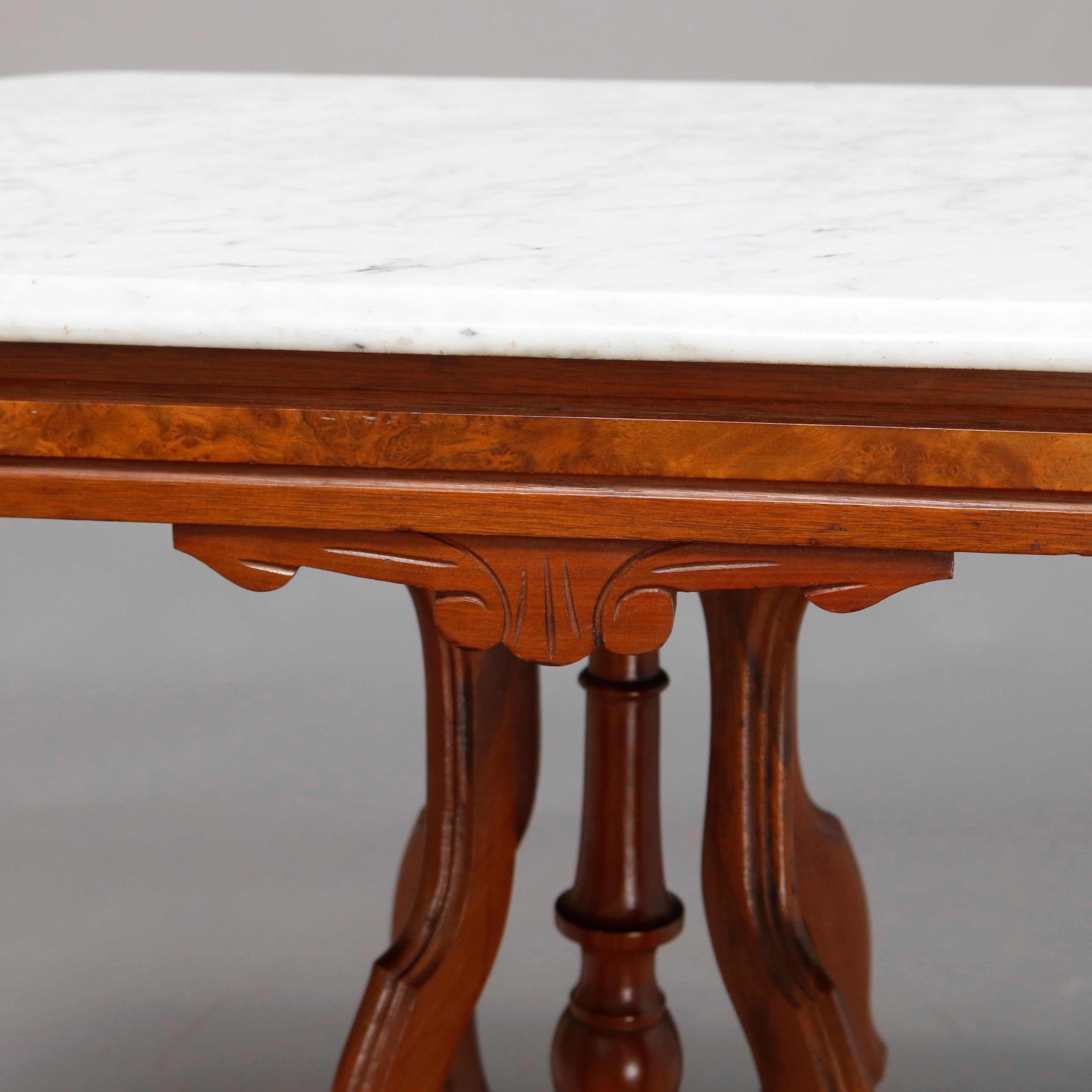 An antique Victorian Eastlake side table offers a beveled rectangular marble top surmounting carved walnut frame having shaped skirt with burl inset, raised on shaped legs with central turned column and drop finial, circa 1880

Measures: 30.25