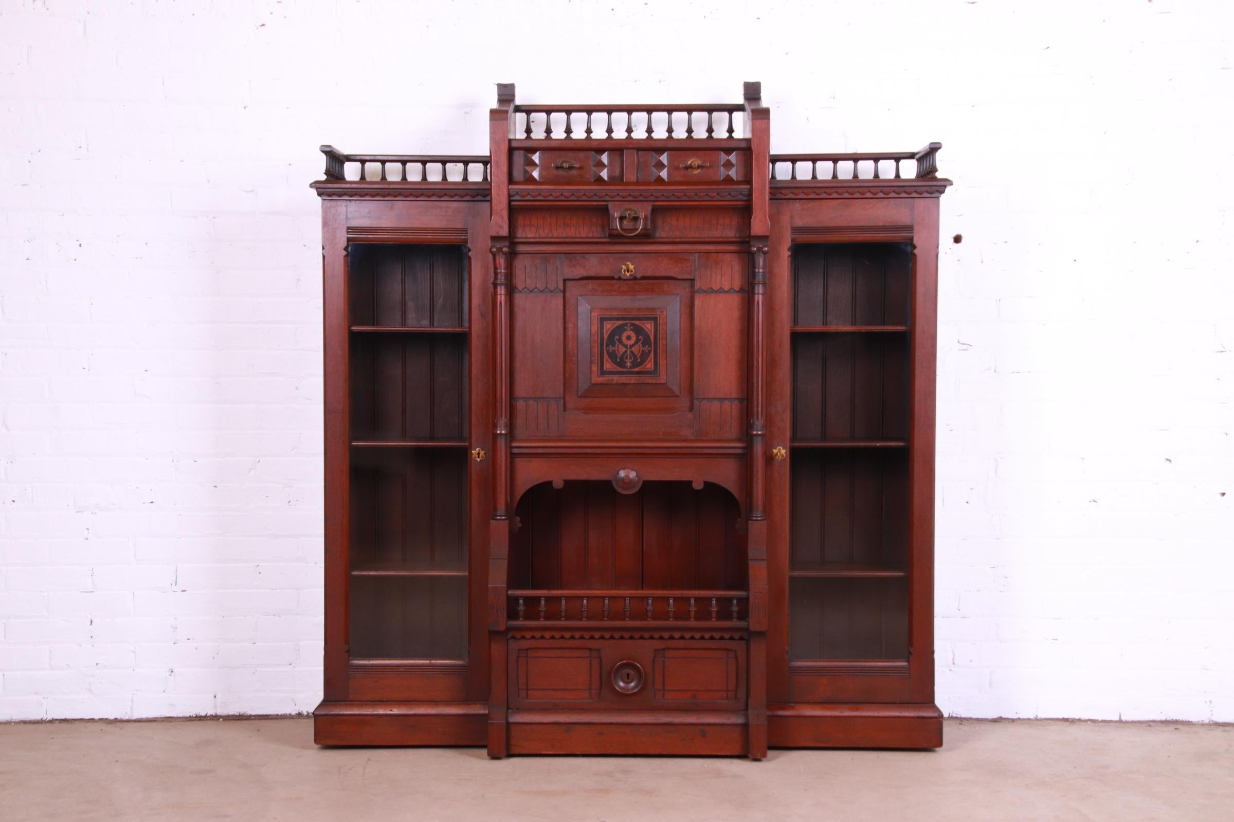 A beautiful antique Victorian Eastlake double bookcase cabinet with drop front secretary desk

USA, Circa 1870s

Carved solid walnut, with glass front doors and original brass hardware. Cabinet locks, and key is included.

Measures: 59.25