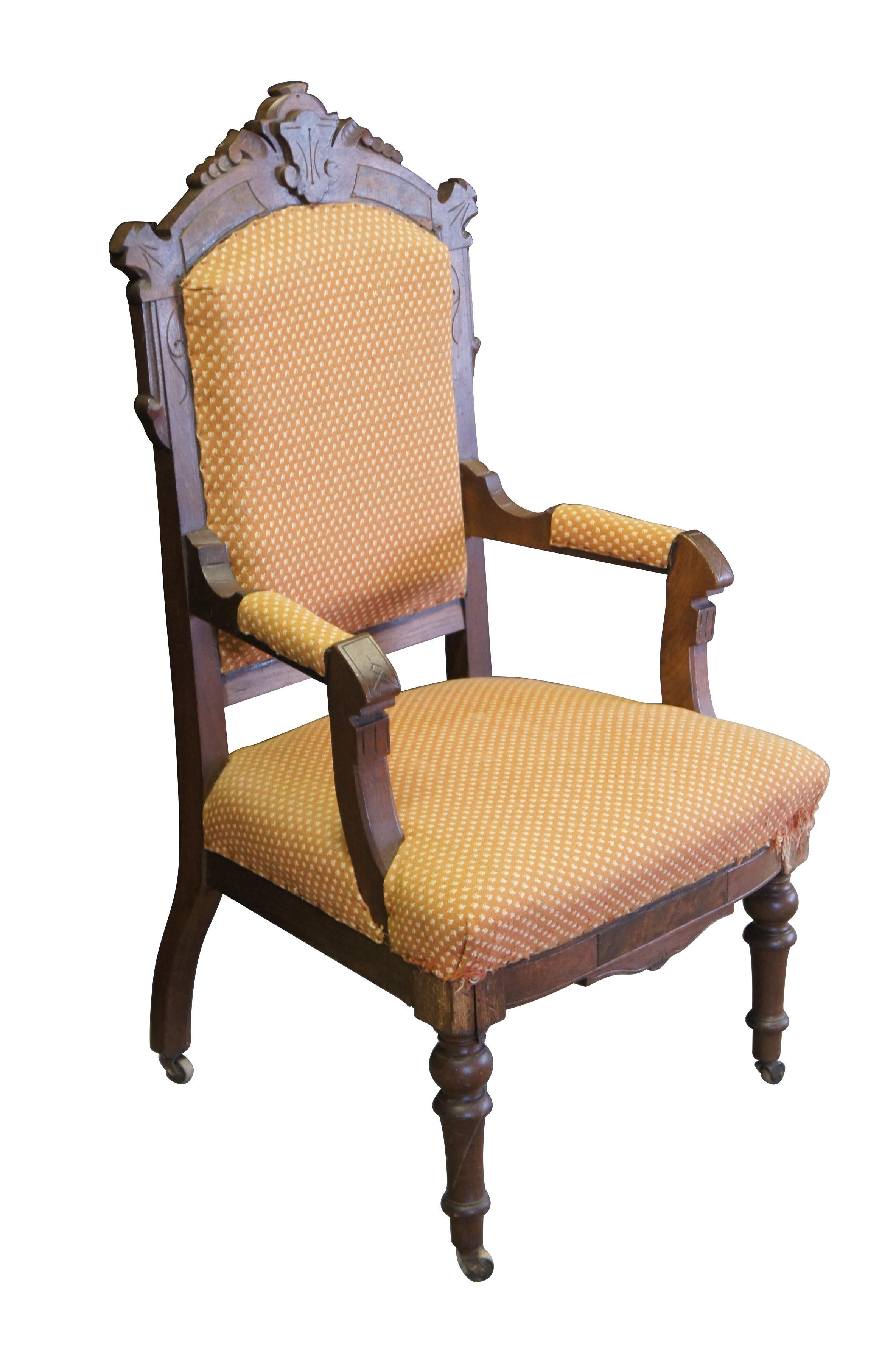 Antique Victorian parlor armchair.  Made of walnut featuring Eastlake styling with carved frame, fauteuil arms and turned legs with castors. 

Dimensions:
23