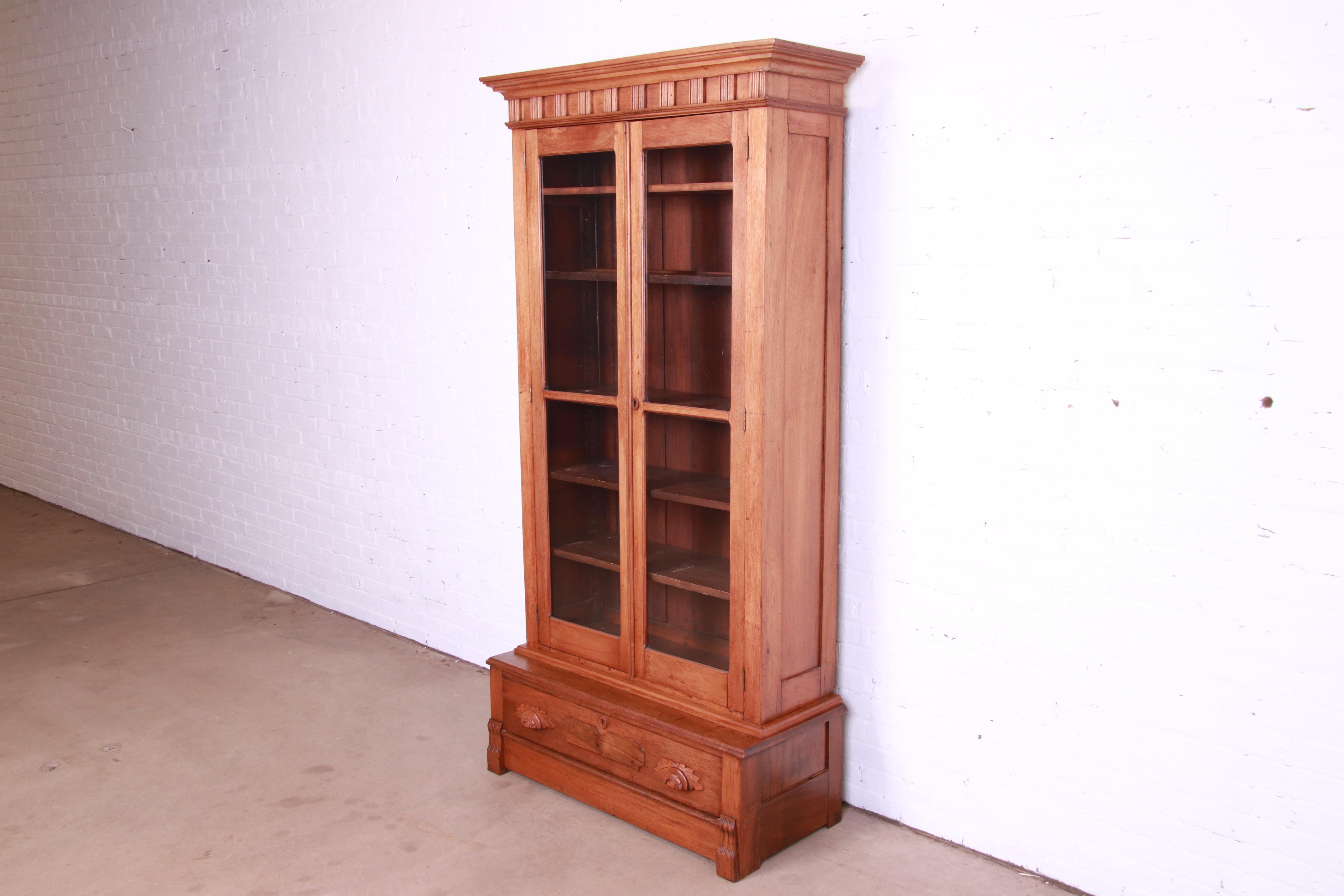 A beautiful antique Victorian Eastlake bookcase cabinet

USA, Circa 1880s

Carved solid walnut, with glass front doors.

Measures: 38.25