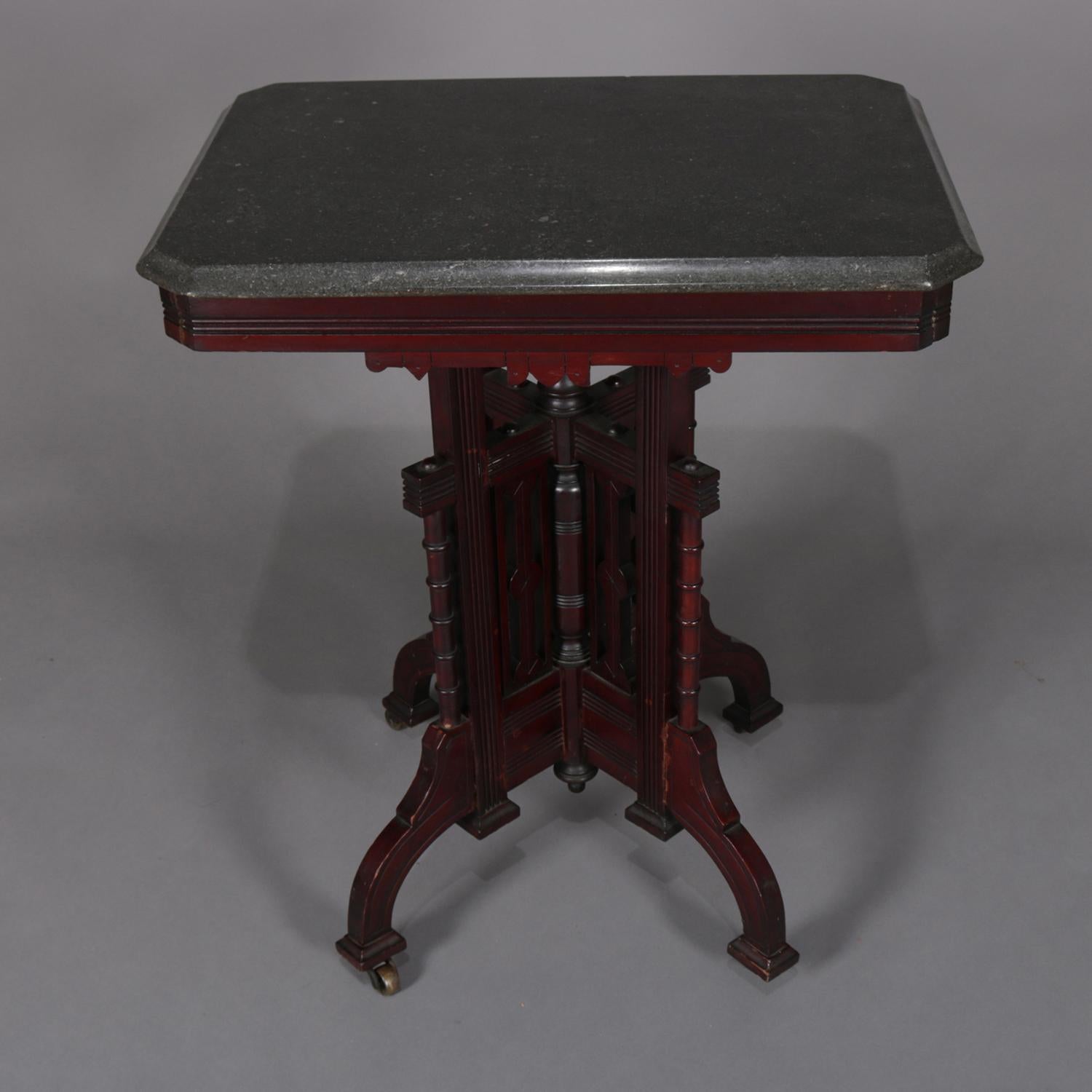 Antique Eastlake side stand features bevelled marble top seated on carved walnut base having shaped skirt above elaborate plinth with carved panels and columns and seated on four convex legs surrounding central drop finial, circa 1890.

Measures: