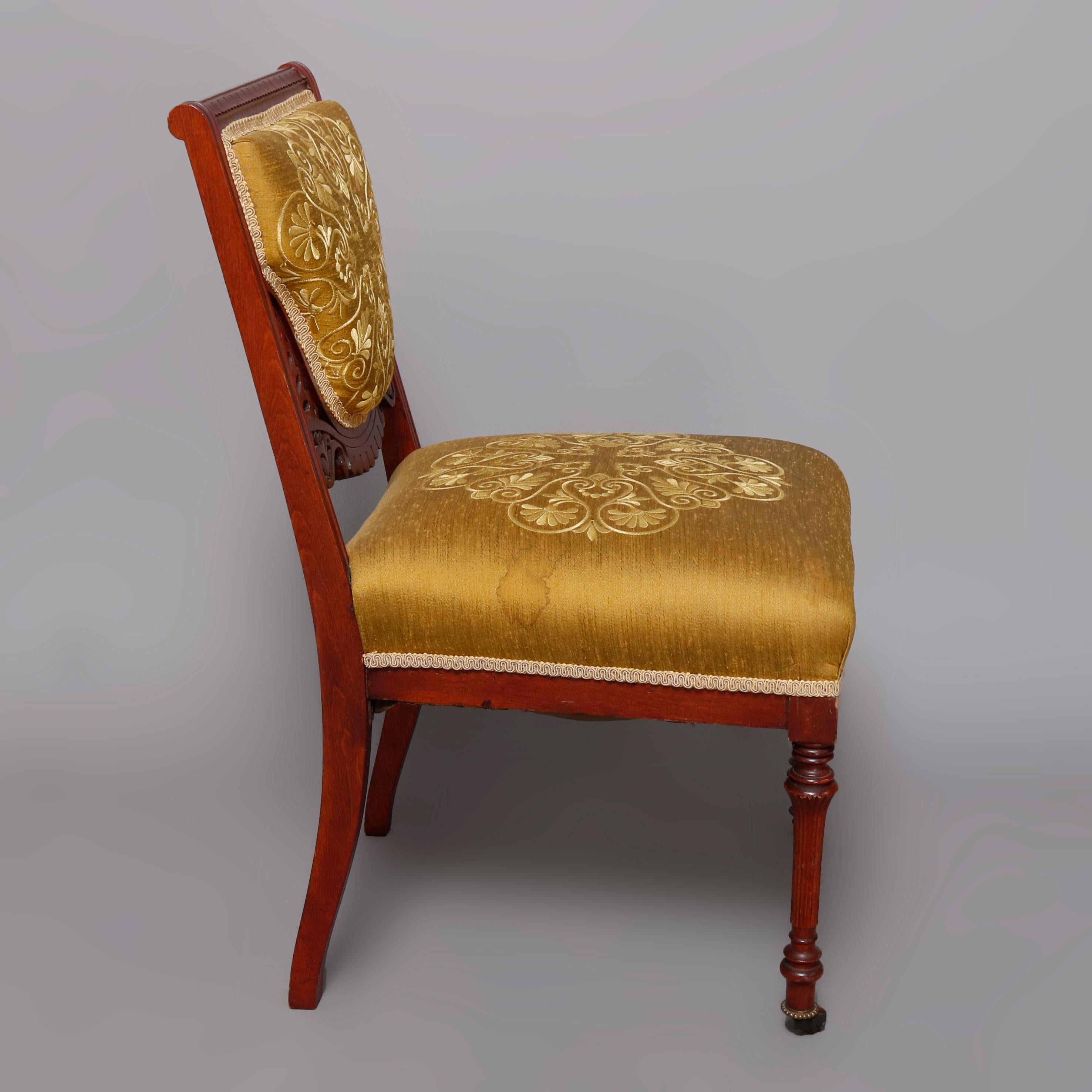 An antique Victorian Eastlake side chair offers carved walnut construction having back with shaped and embroidered upholstery, flanking pierced scroll form corbels 
 and surmounting matching cushioned seat raised on turned and tapered legs, early