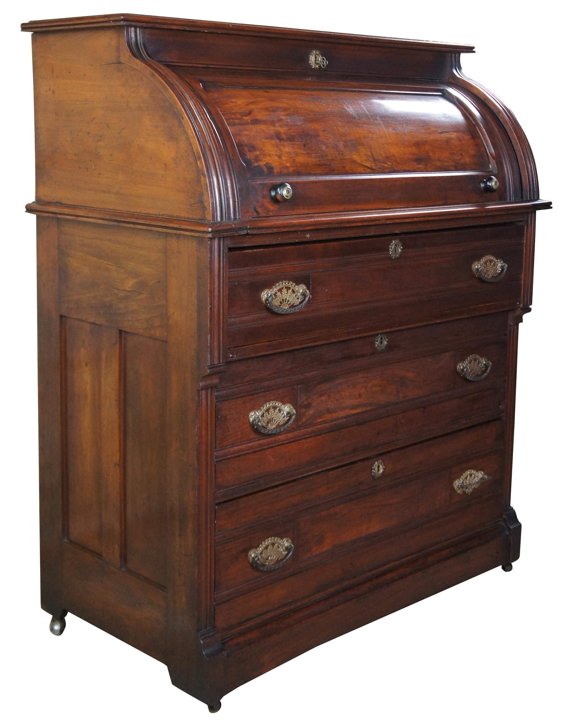 Antique Victorian period Eastlake cylinder roll top secretary writing desk, circa 1880s. Made of walnut featuring lower chest with three drawers, a half cylinder roll top that opens to pullout writing surface with multiple drawers and cubbies, and