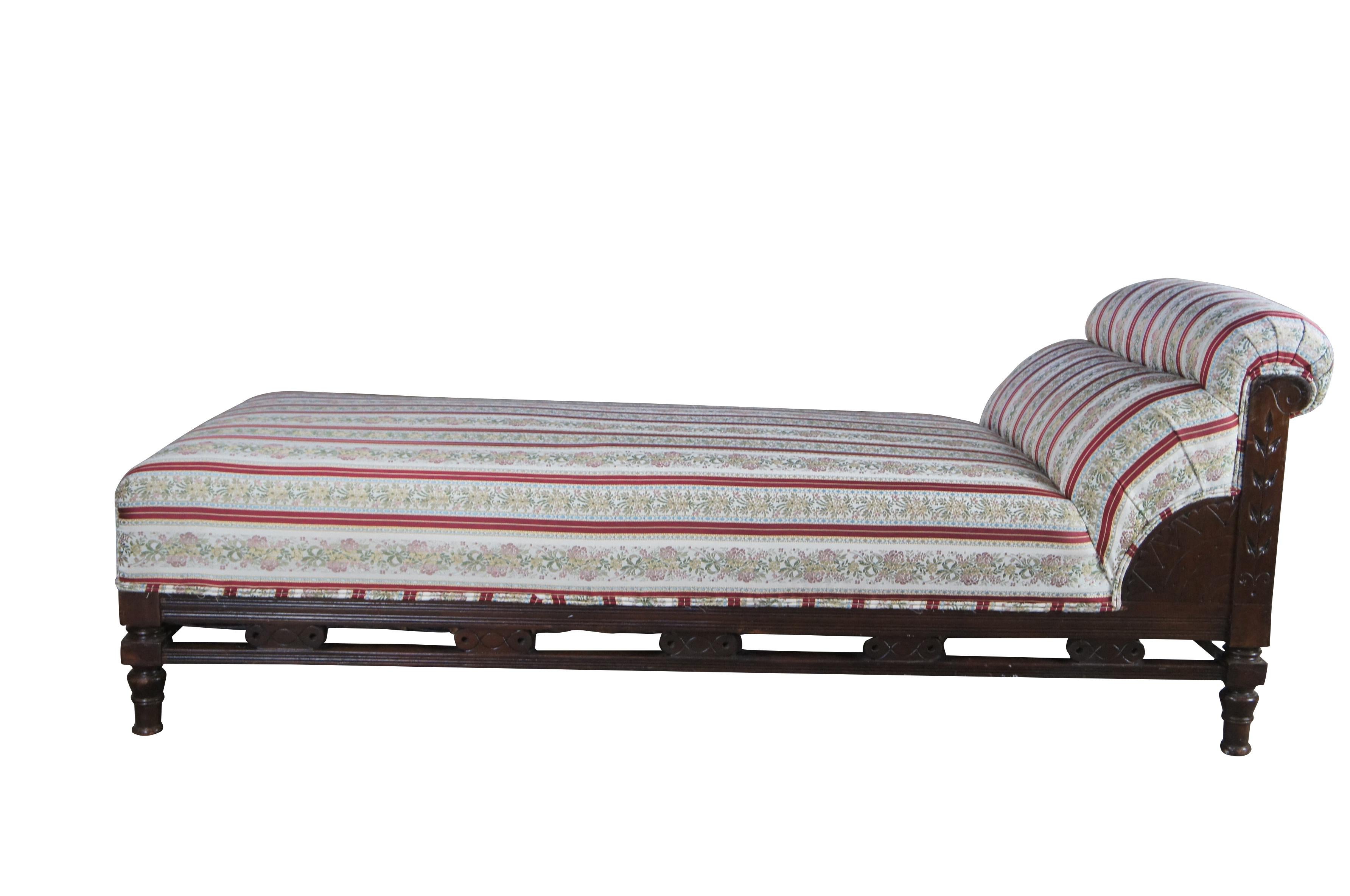 Antique Victorian parlor day bed / fainting couch / chaise lounge.  Made of mahogany featuring traditional Eastlake styling with pierced / reticulated frame and Neoclassical striped floral and ribbon fabric with double cording.  A very comfy and