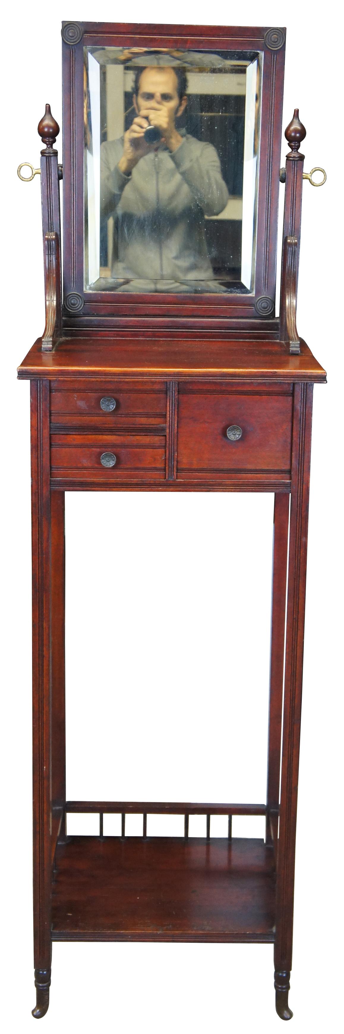 Victorian washstand or shaving stand, circa 1880s. Made from mahogany with three drawers, lower shelf and adjustable mirror. Lower shelf features a unique spindled gallery that is neatly placed above the flared meet.
  
