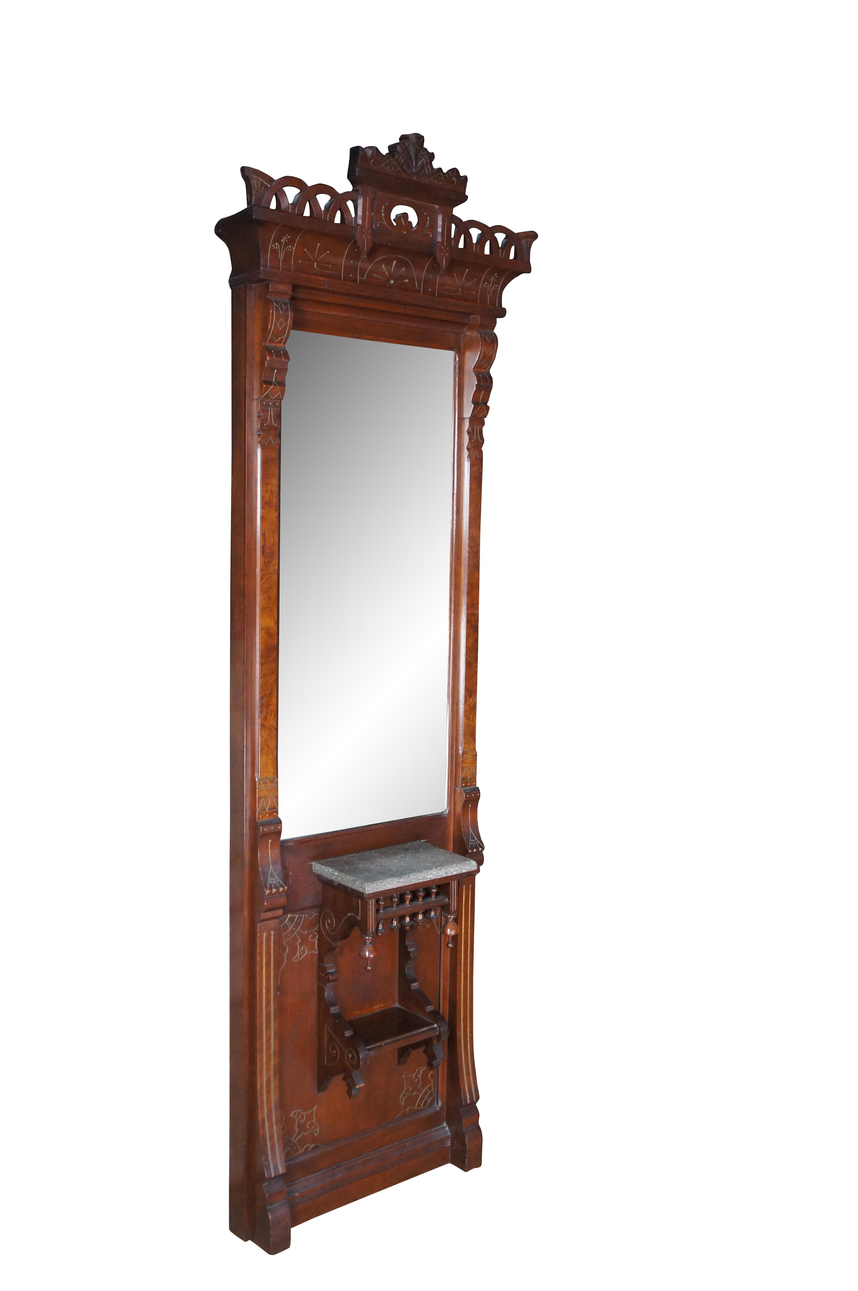 Antique Victorian / Aesthetic period hall pier mirror.  Made of mahogany featuring Eastlake styling with pierced / reticulated crown, flamed panels and granite top table / stand.

Dimensions:
23