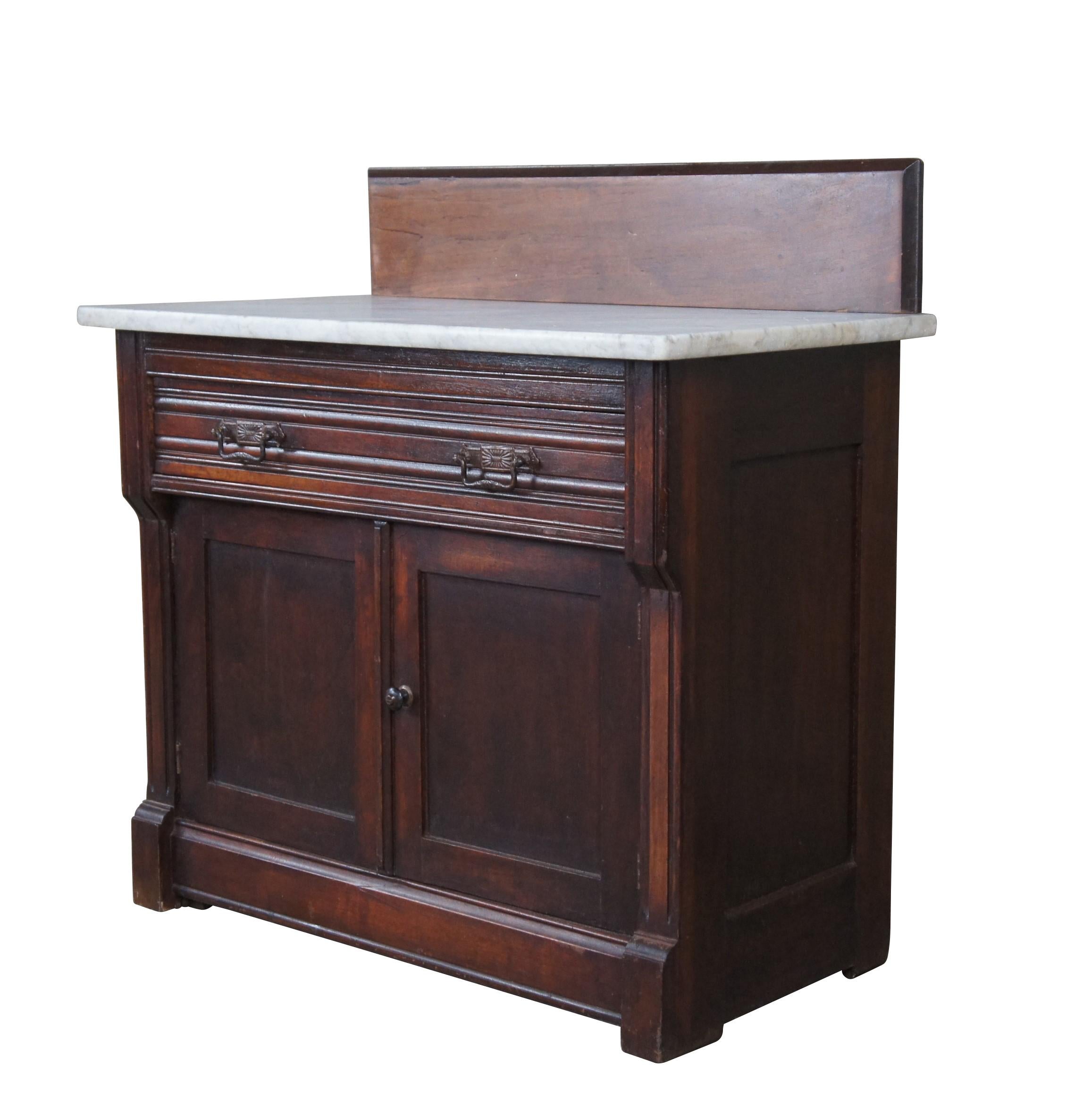 Antique Victorian wash basin cabinet.  Made of mahogany featuring Eastlake / Aesthetic styling with white marble top over one large drawer and lower cabinet.

Dimensions:
32