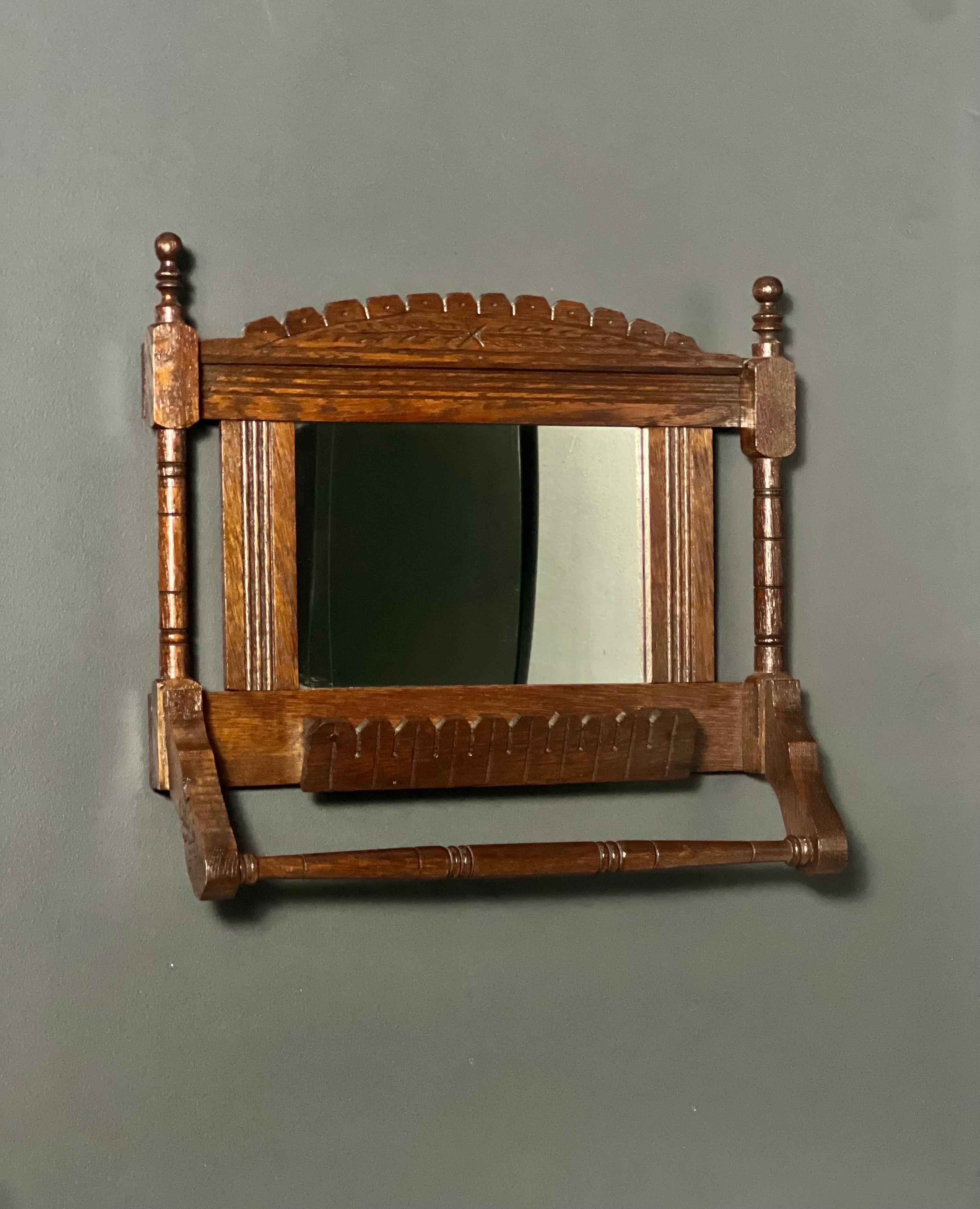 Antico specchio da parete da barba in stile vittoriano Eastlake in quercia con barra per asciugamani e mensola per pettine. Presenta il classico design Eastlake con intagli geometrici e linee incise. Un'attenzione particolare per i dettagli e per lo