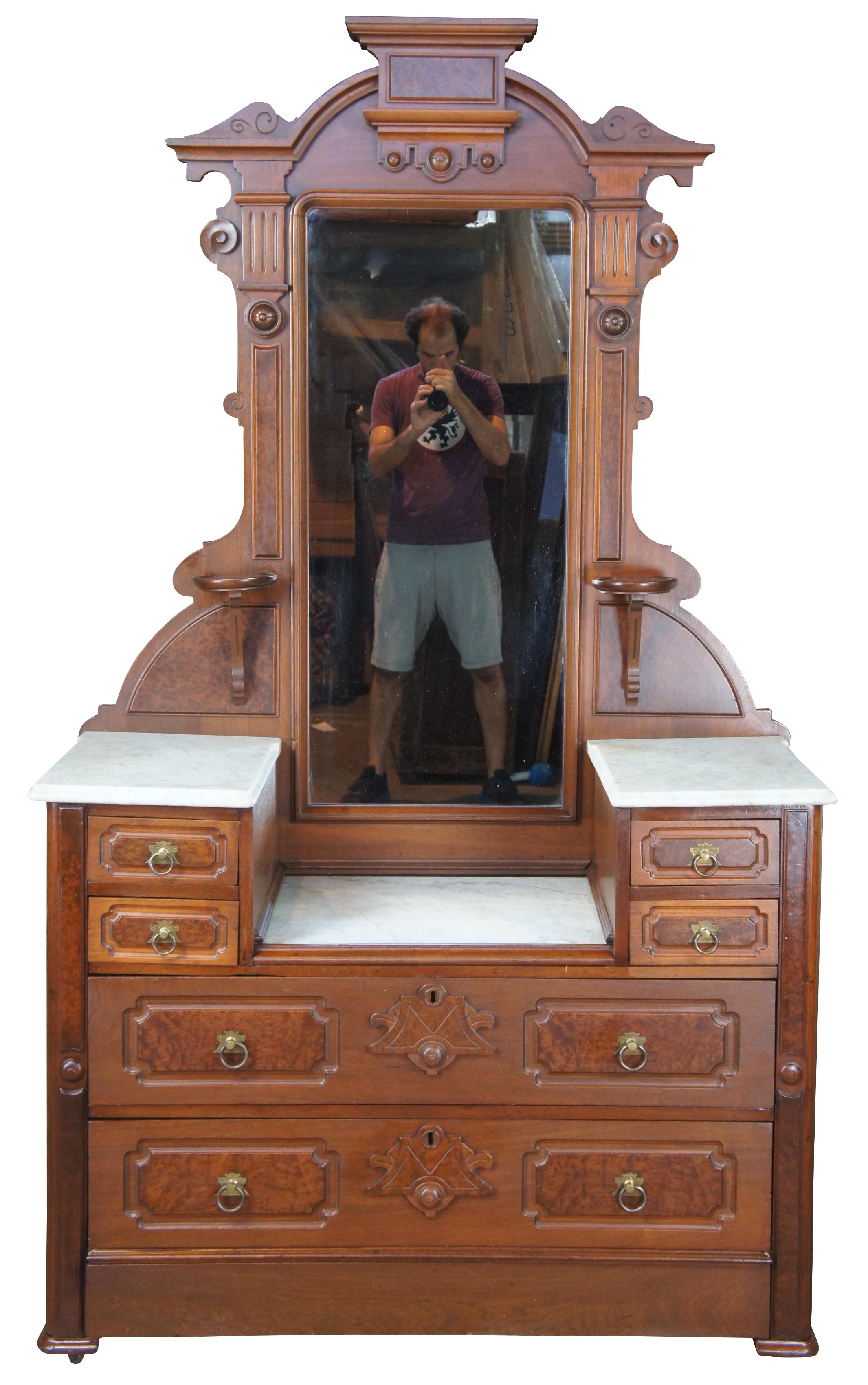 Antique Victorian Eastlake gentleman's dresser or vanity. Made of walnut featuring carved burl panels and ornate fluted and turned accents. The dresser has two candle or shaving stands, three marble tops, four small drawers and two larger, all