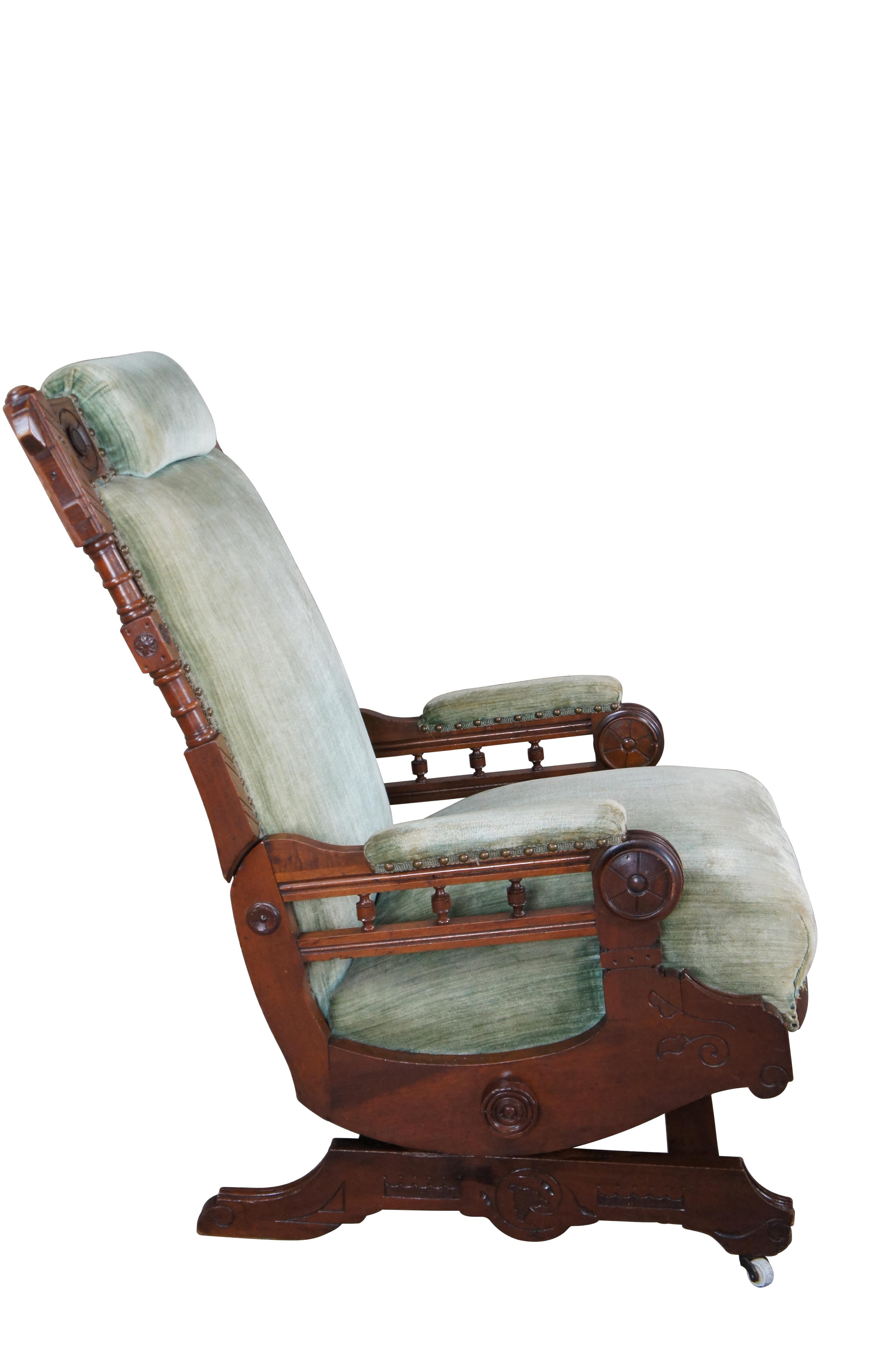 Antique Victorian platform rocking armchair.  Made of walnut featuring Eastlake styling with turned foliate and wheel designs, padded arms / headrest, and nailhead trim.  Upholstered in green velvet.  Rock, Hughes & Co., Furniture & Rugs , Urbana