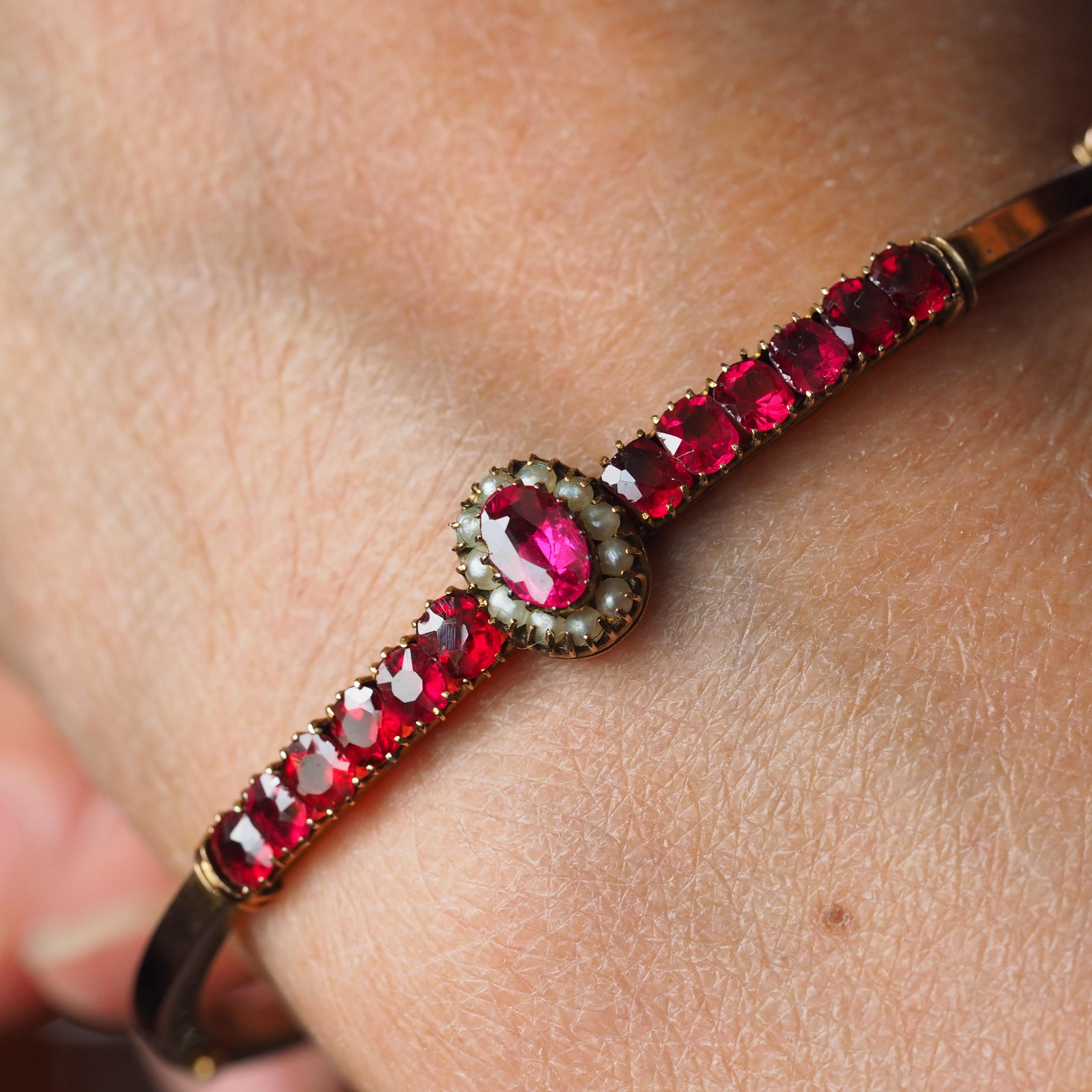 We are delighted to offer this charming antique late Victorian/early Edwardian gold bangle made c.1900.

The bangle is made from solid antique 9ct gold and in spectacular fashion. Featuring a central cluster design and an ornate single row of pink