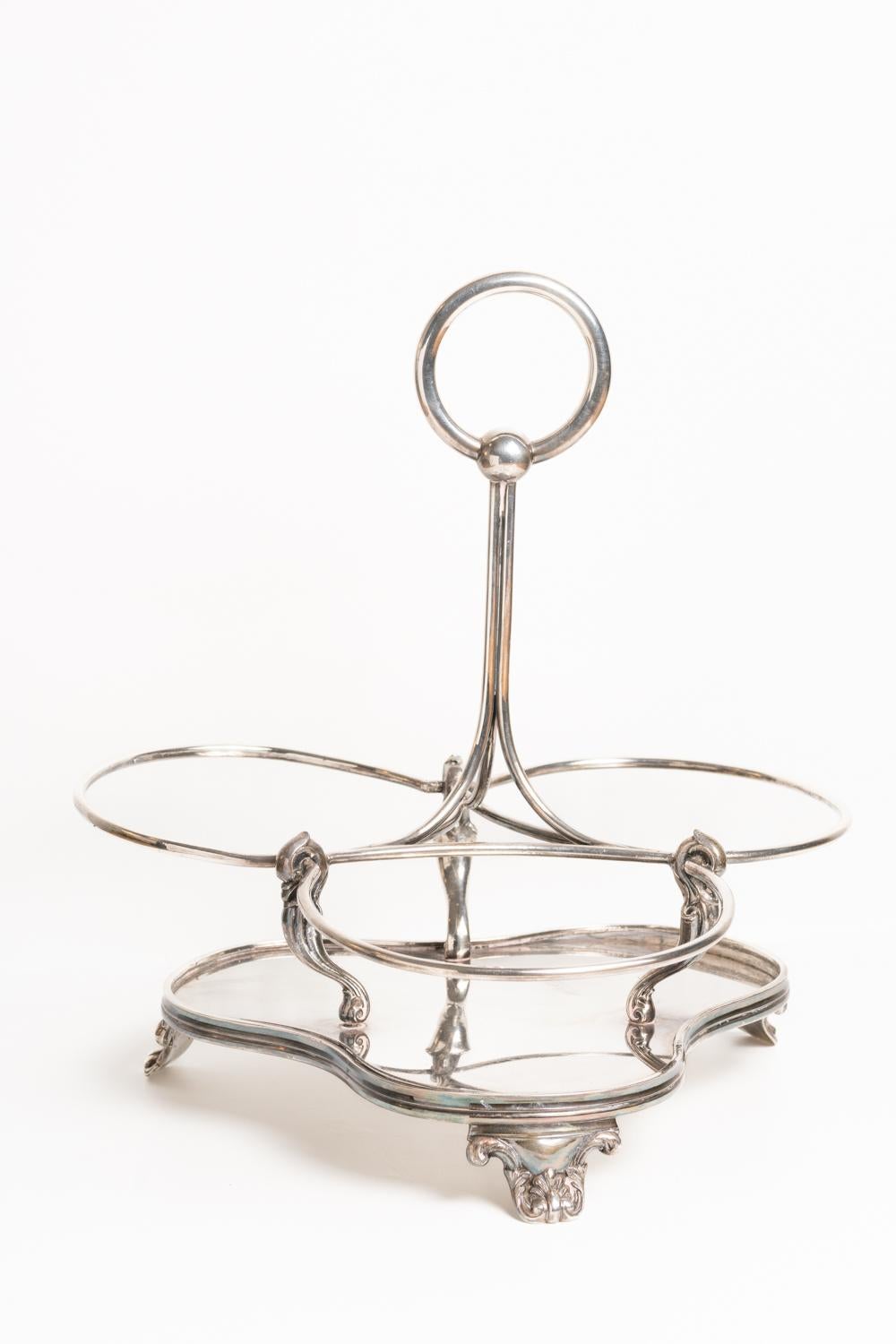 Rare Elkington Victorian Silver Plate Three Bottle Decanter Stand Tantalus, circa 1869. This beautiful and classic silver plated decanter holder has a central stem with a loop handle and the three decanters sit in circular wells each supported with