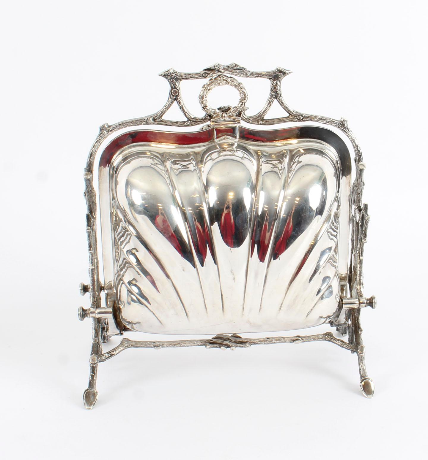This is a beautiful antique Victorian silver plated folding biscuit box, the base bearing the makers mark of the renowned retailer Elkington & Co of Birmingham, circa 1870 in date.
 
It has a shaped shell shaped body sitting in a cast frame in the