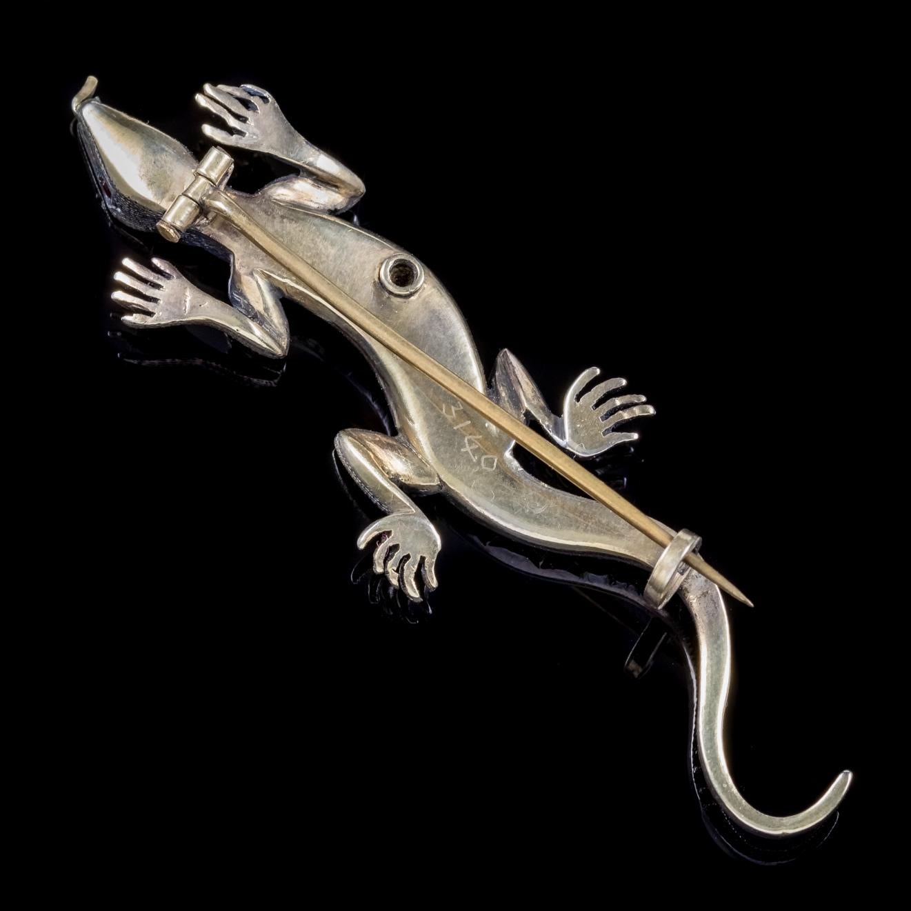 A wonderful antique Lizard brooch C. 1900, adorned with a beautiful green stripe of Emeralds down the back, with Diamond encrusted legs and red Ruby eyes. 

Victorian jewellery mirrored Queen Victoria’s life with the ‘Romantic’ period producing