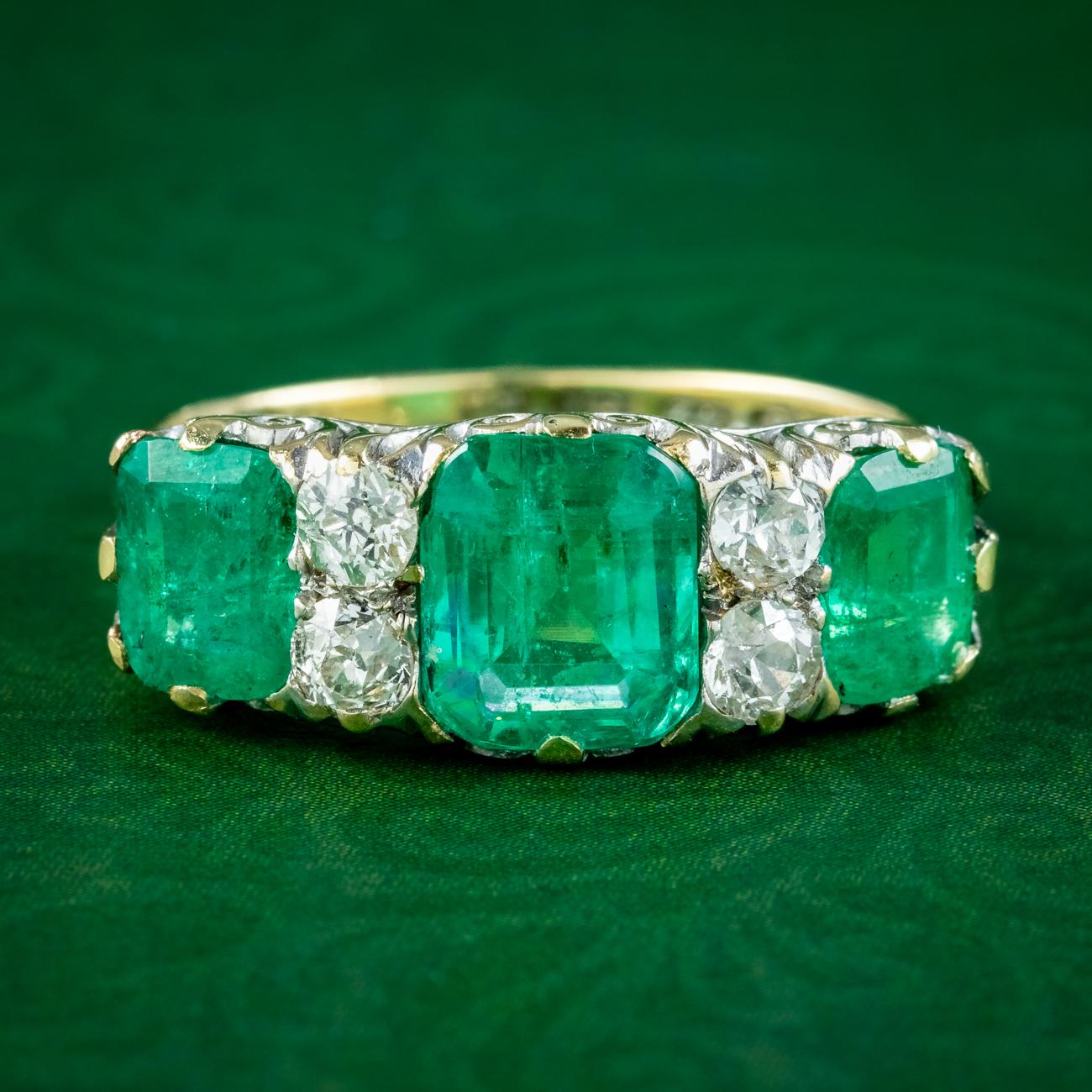 A magnificent antique Victorian carved half hoop ring adorned with three large step-cut emeralds and four old European cut diamonds which are all natural and detailed in the accompanying gem certification.

The emeralds have a bright, vivid green
