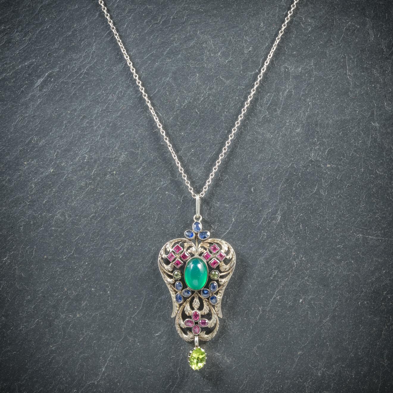 A stunning antique Gemstone pendant necklace from the Victorian era, Circa 1880

The beautiful pendant is decorated in pink Rubies, blue Sapphires, white Spinels with a bright green Peridot dangling below

Most striking is a stunning rich green
