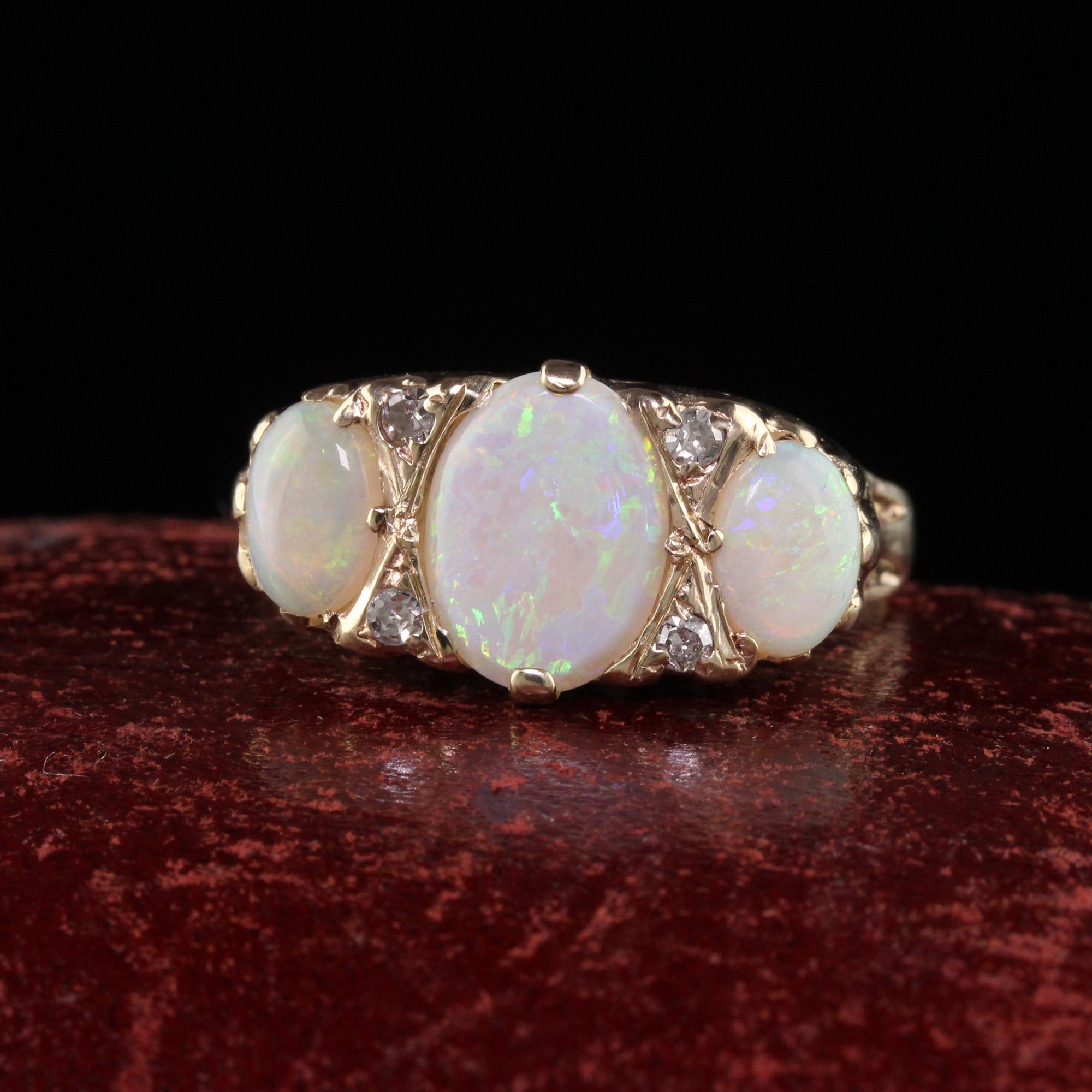 Beautiful Antique Victorian English 10K Yellow Gold Opal three Stone Ring. This gorgeous ring is crafted in 10k yellow gold. The ring holds three beautiful opals that have beautiful color play. There are small old cut diamonds in between the prongs