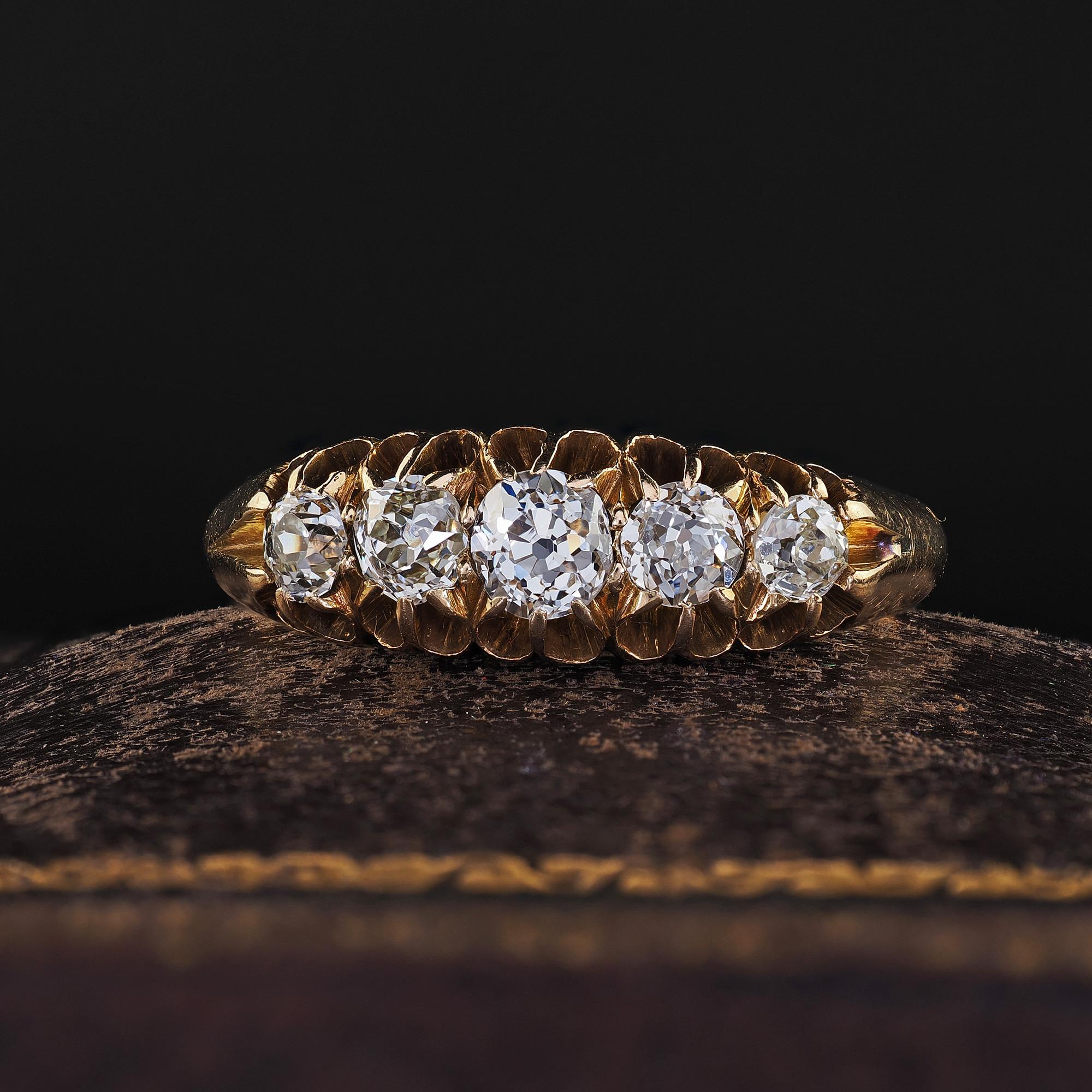 Beautiful Antique Victorian English 18K Yellow Gold Old Mine Diamond Five Stone Band. This beautiful Victorian English old mine diamond band is crafted in 18k yellow gold. This ring features five chunky old cut diamonds set on top of a beautiful low