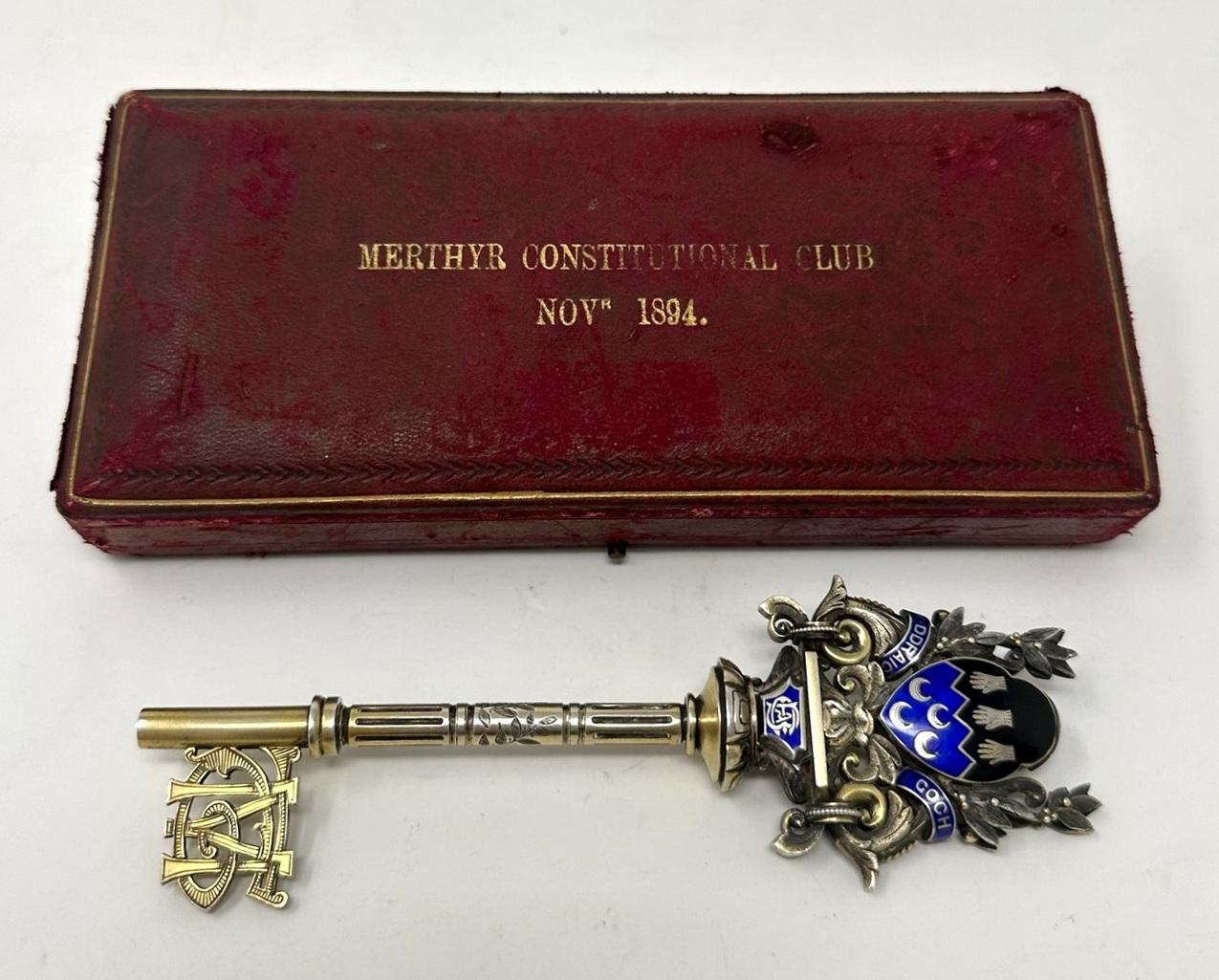 Ein äußerst ungewöhnlicher vergoldeter silberner Präsentations-Türschlüssel, der 1894 für den Merthyr Constitutional Club in Wales, England, modelliert wurde, komplett mit seiner originalen seidengefütterten Schachtel.  

Der extrem verzierte Griff
