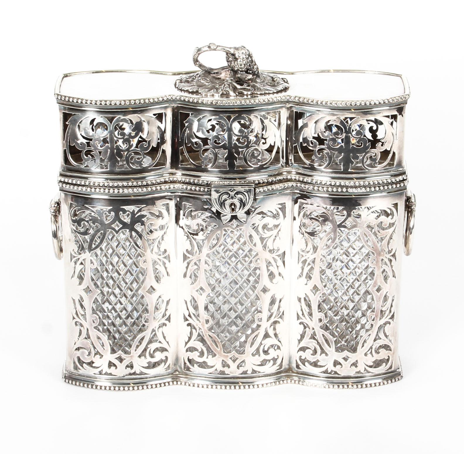 This is a highly decorative Victorian English silver plated three bottle tantalus, circa 1880 in date.

This wonderful tantalus has a stunning shaped openwork design featuring delightful scrolls and an elegant beaded border. It has two attractive
