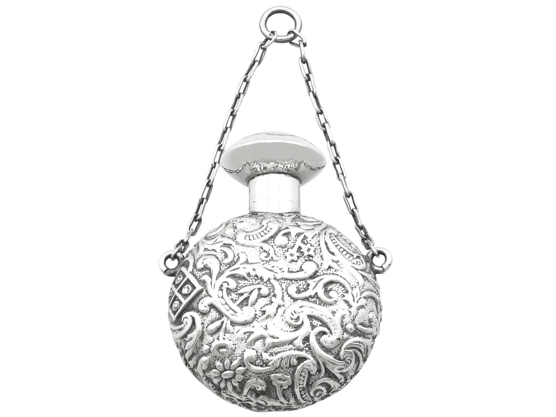 A fine and impressive antique Victorian English sterling silver scent flask; an addition to our ornamental silverware collection.

This fine antique Victorian sterling silver scent flask has a circular, moon flask form.

The surface of the flask