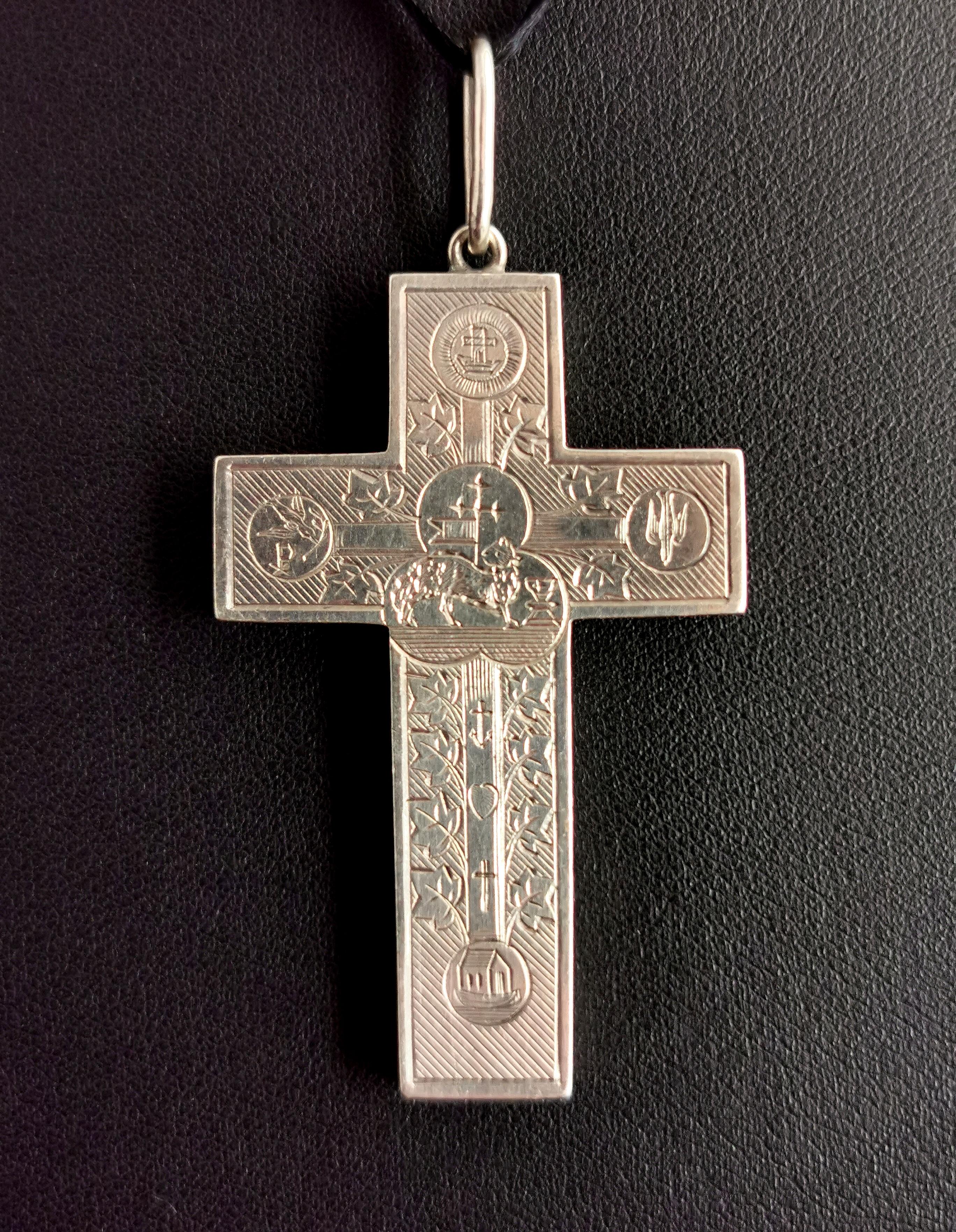 A beautiful and rare antique Victorian silver cross pendant.

This special piece is heavily engraved with various religious symbols to the front.

Amongst others there is Noahs Ark, The dove of peace carrying an olive branch, Saint Esprit and the