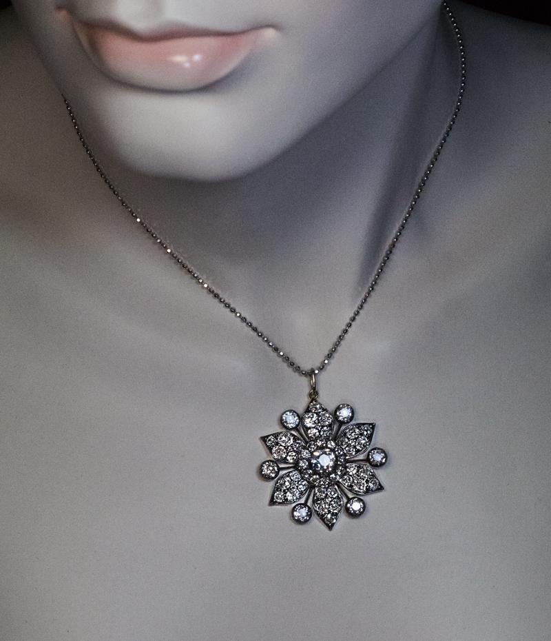 Circa 1870

This antique mid-Victorian era pendant is designed as a stylized flower or a snowflake densely set with chunky and bright white old mine cut diamonds. The diamonds are set in silver over 14K gold.

The center stone is approximately 1.10
