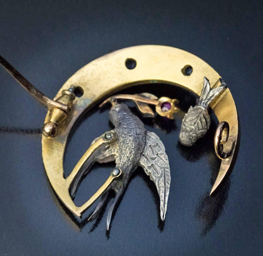 Russian, 1870s-1880s

A Victorian era 14K gold brooch with two birds and a crescent moon, is embellished with rose cut diamonds, rubies, and sapphires.

The birds are made of silver and have fine feather details. The bigger bird, carrying a flower,