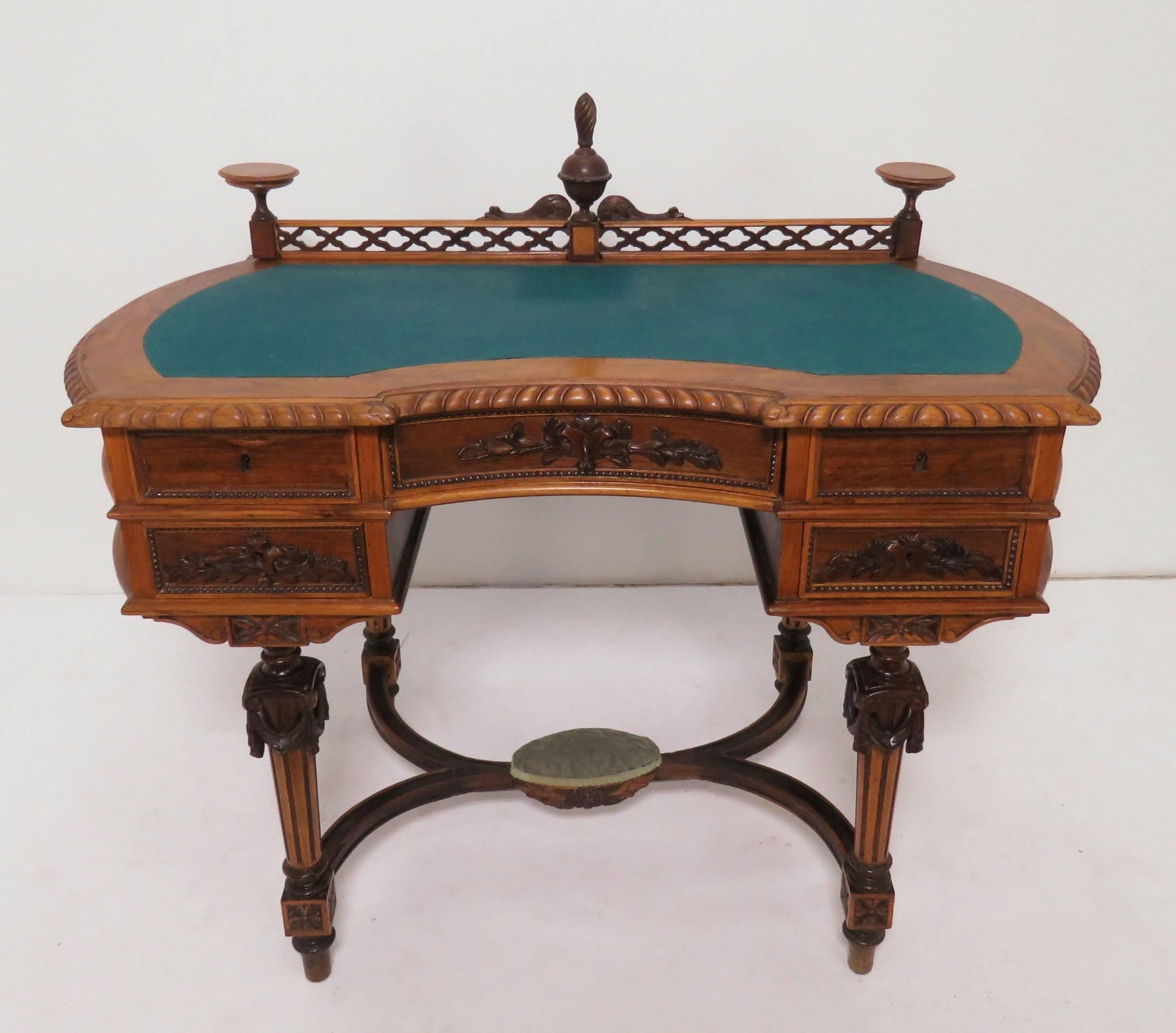 An Austro-Hungarian ladies writing desk with felt top, decorative carved back rail, carved legs and stretcher with foot rest, circa 1860s.

Measures: Writing surface height 31