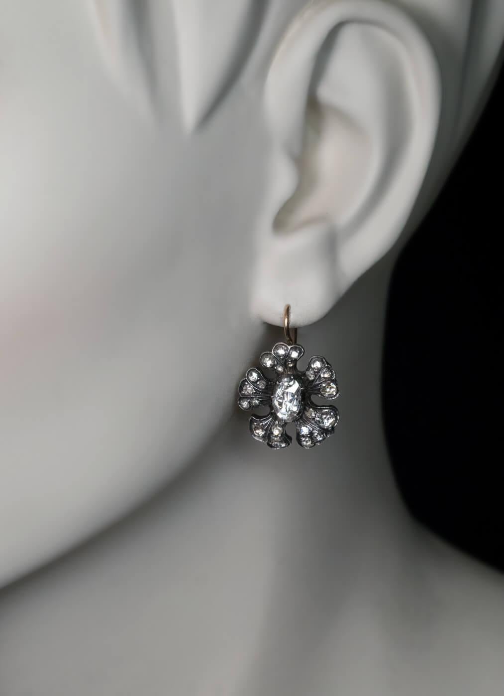 Circa 1860  The earrings are designed as stylized flower heads embellished with antique rose cut diamonds of various shapes and sizes (H-I-J color, VS-SI clarity). They are crafted in silver-topped 14K gold (front – silver, back – gold).  Total
