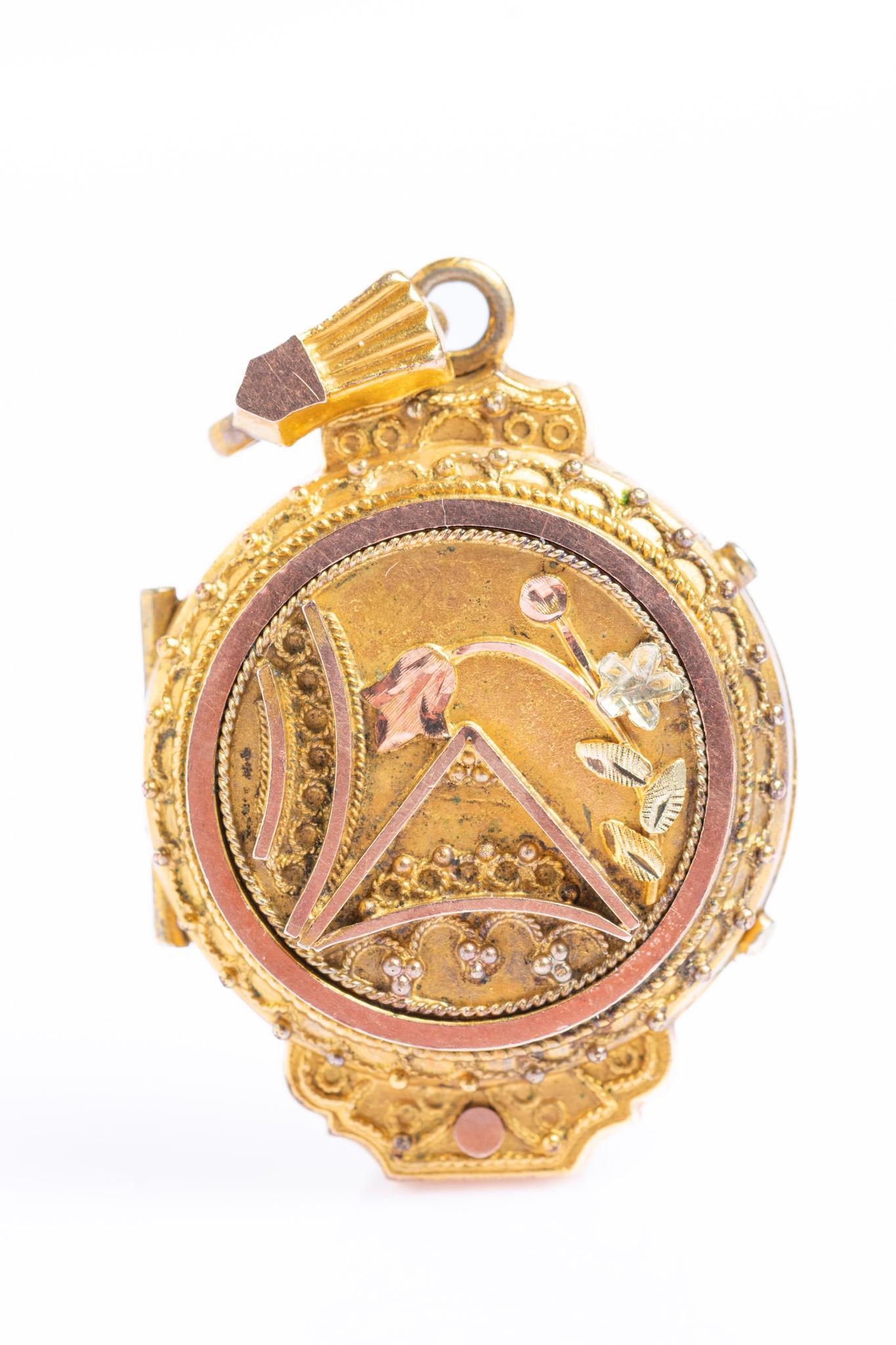 Questo magnifico e rarissimo medaglione vittoriano Etruscan Revival risale al 1880 circa ed è realizzato in oro giallo e rosa 9ct, con un motivo a bouquet di fiori sul davanti, accentuato da una sottile filigrana Etruscan Revival. Il medaglione è