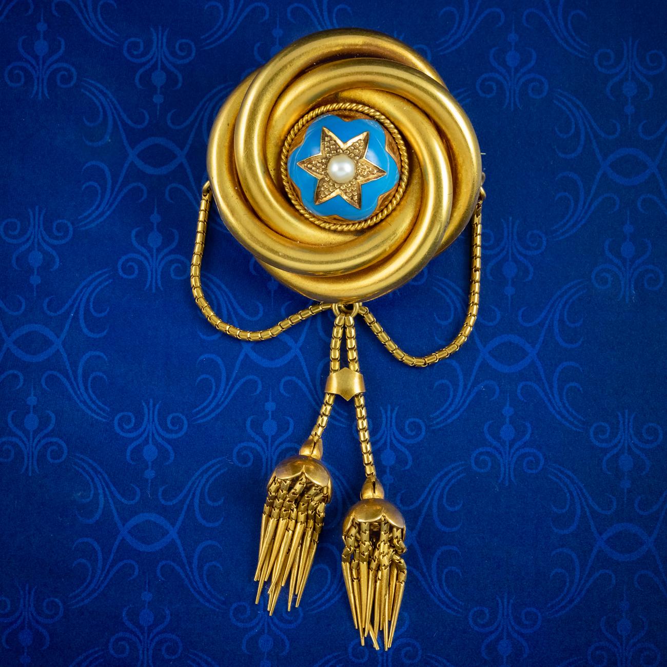 A remarkable antique Victorian Etruscan revival brooch made by established Manchester based jewellers Ollivant & Botsford in the late 19th Century. The piece consists of a large, knot with a domed centre, layered in sky-blue enamel and topped with a