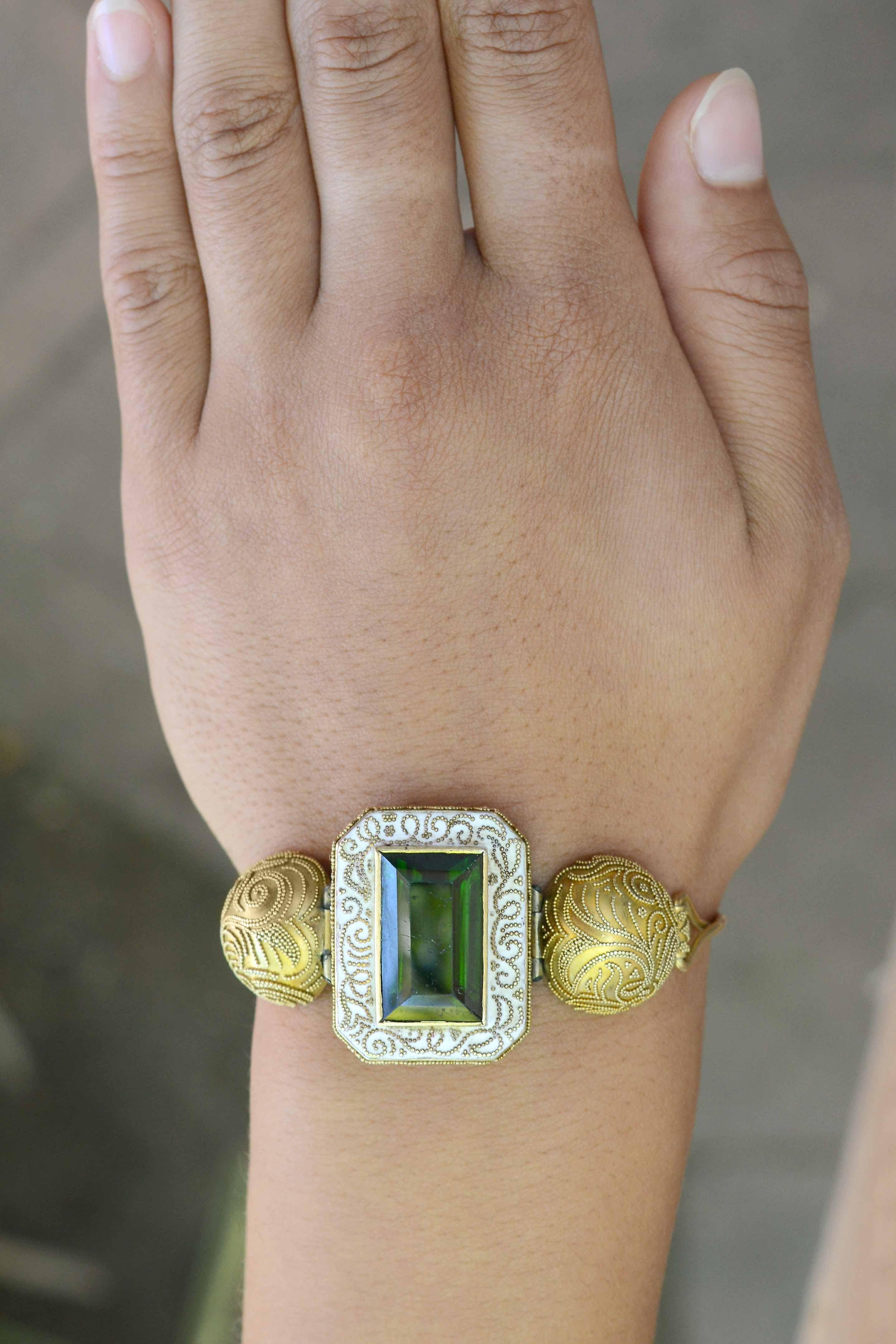 Centered by a significant 23 carat green tourmaline, this incredible antique Victorian Etruscan revival bracelet has that 
