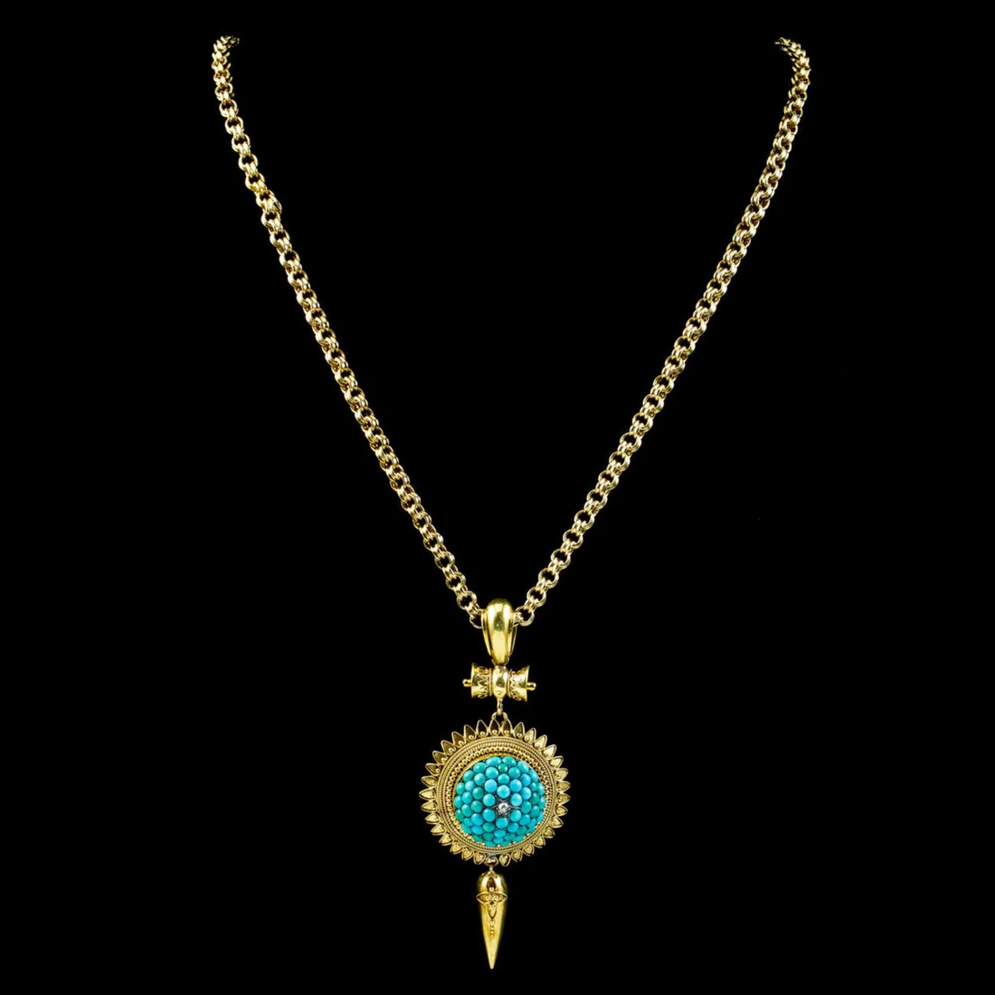 An exquisite antique Etruscan revival pendant from the mid-Victorian era (Circa 1860) depicting an ornate sun with an icicle dropper below. A turquoise encrusted dome also bulges out of the centre and is crowned with a twinkling old mine cut diamond