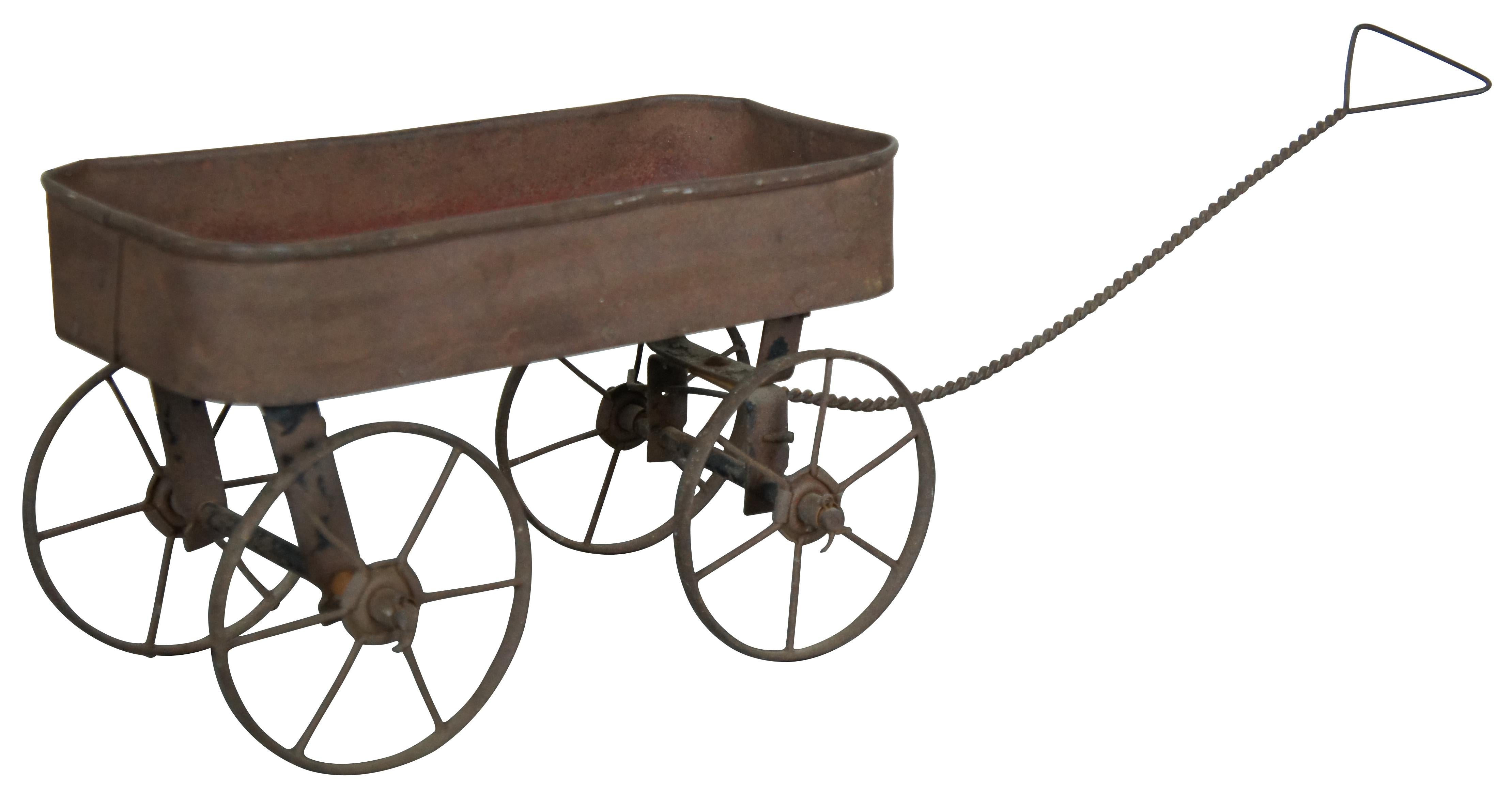 Antique 19th century folk art child’s doll sized farmhouse wagon or cart with metal body, wood base, twisted wire handle, and metal wheels, the front axle of which rotates in all directions.

13” x 6.25” x 8”, Handle Length – 17”
