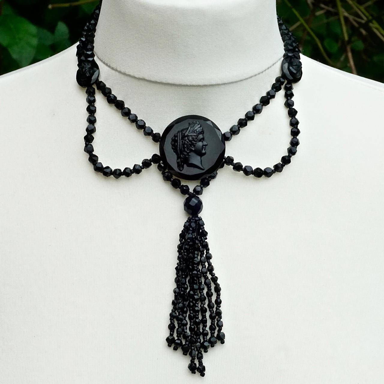 Antique Victorian festoon faceted french jet bead necklace with a sterling silver clasp, featuring three lovely cameos and finishing with a long tassel. The cameos have faceted edges and black enameled metal backs. Each hand cut bead is interspersed