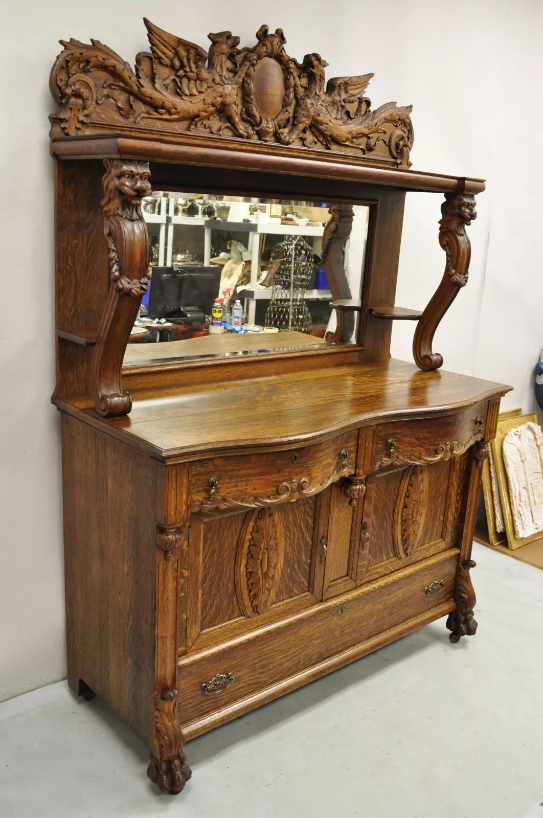 Antique Victorian Figural Lion & Griffin Carved Oak Wood Sideboard Buffet. Item features a mirrored back, 2 part construction,  carved griffins and lions, rolling casters, paw feet, unlocked, no key. Very nice antique sideboard. Circa Late 19th
