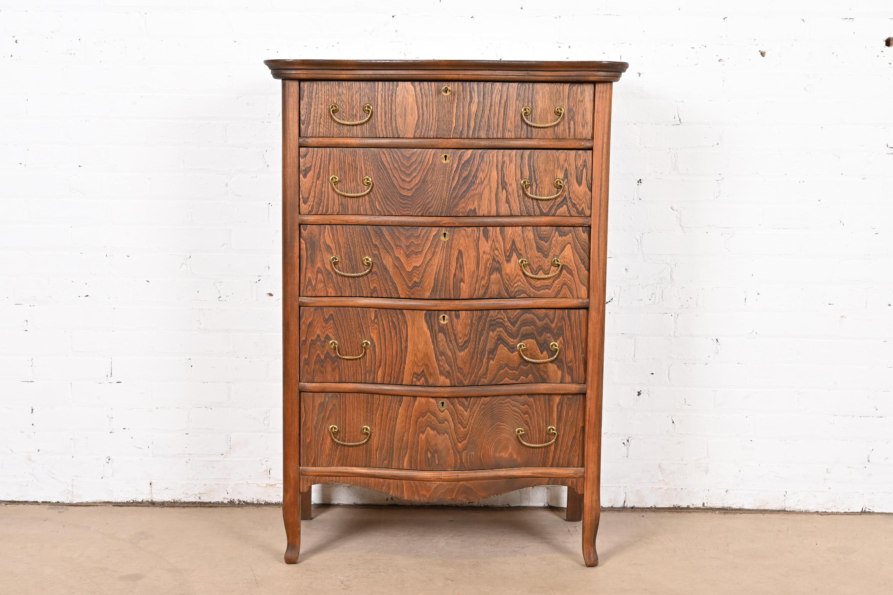 A gorgeous late Victorian or Arts & Crafts style five-drawer highboy dresser

USA, Circa 1900

Beautiful figured oak, with original brass hardware.

Measures: 32
