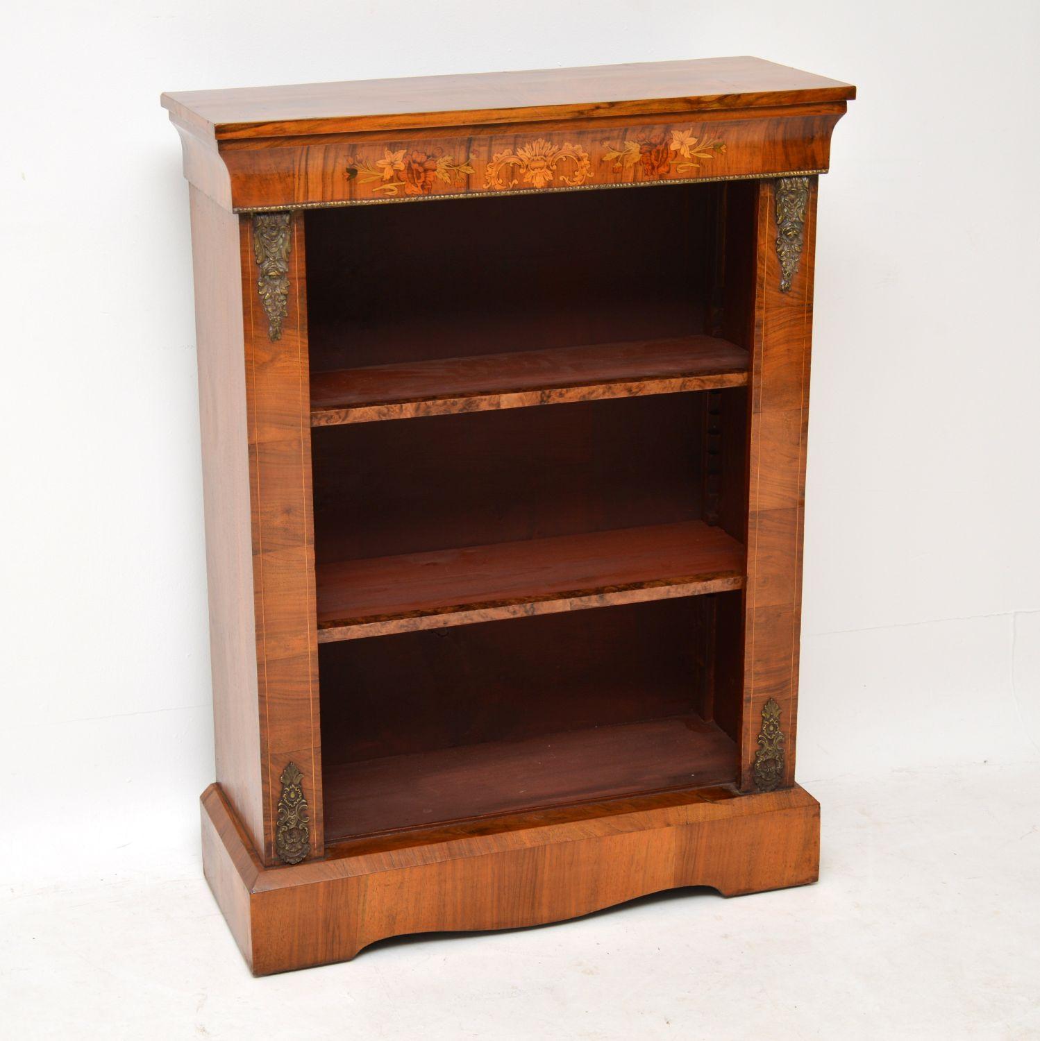 Antique Victorian figured walnut open bookcase dating from circa 1860-1880s period and in good condition. It has a concave top section with some exquisite floral marquetry made up from many exotic woods. The shelves are adjustable on sharks teeth